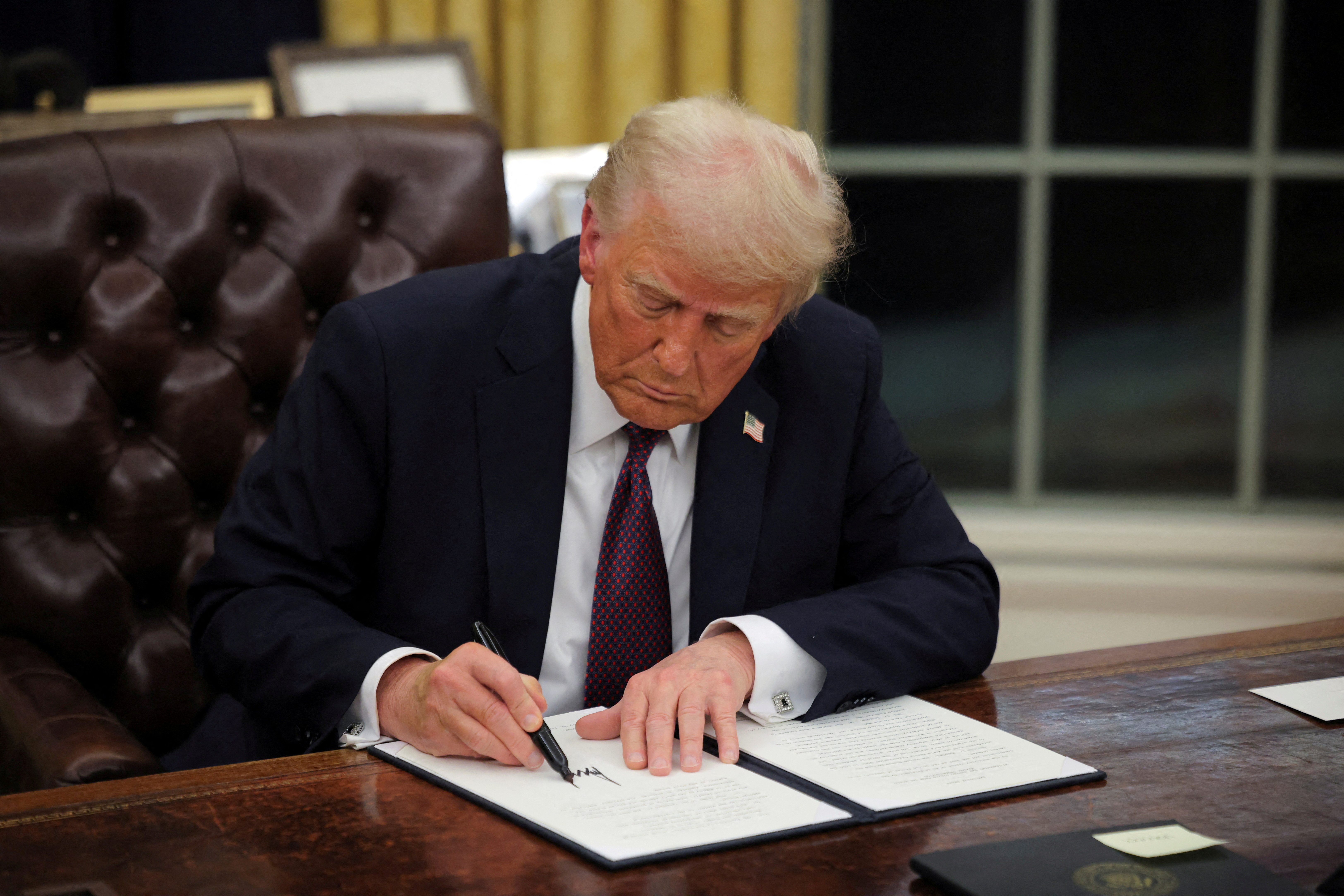 Trump aid freeze stirs chaos before it is blocked in court | Reuters
