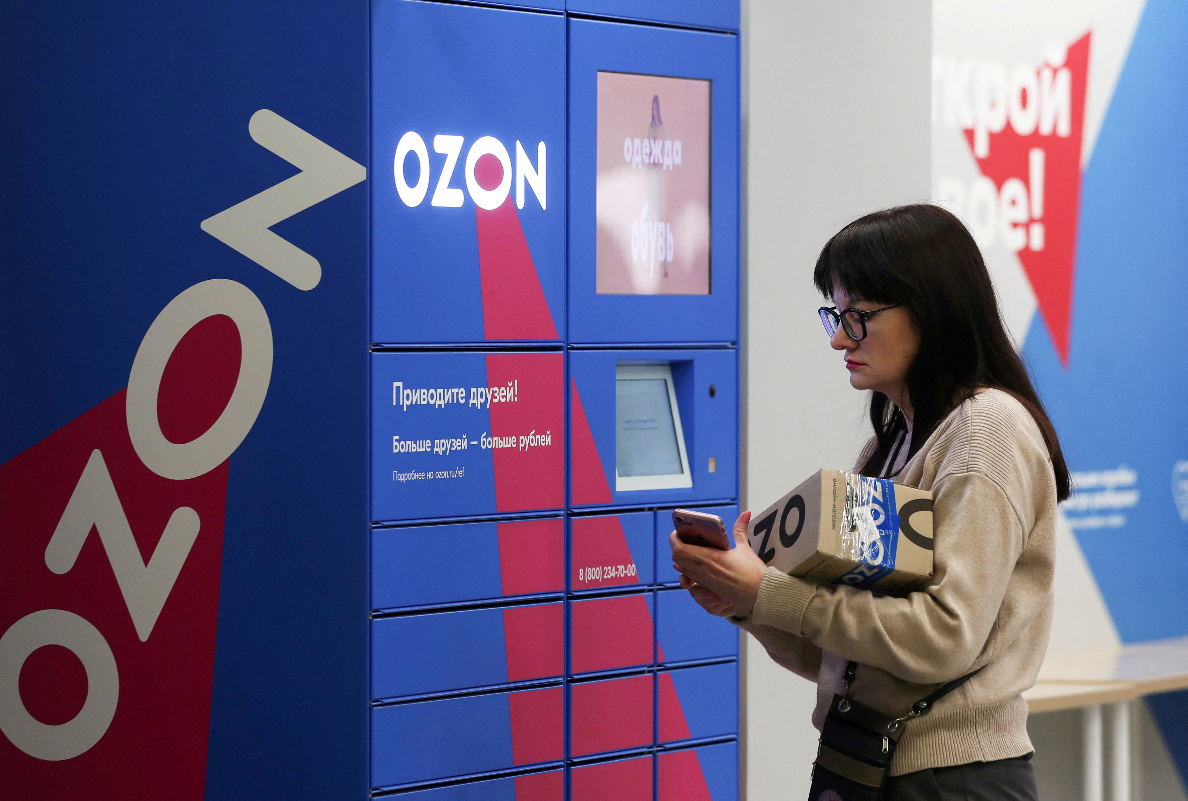 A woman picks up an order at the pick-up point of the Ozon online retailer in Moscow