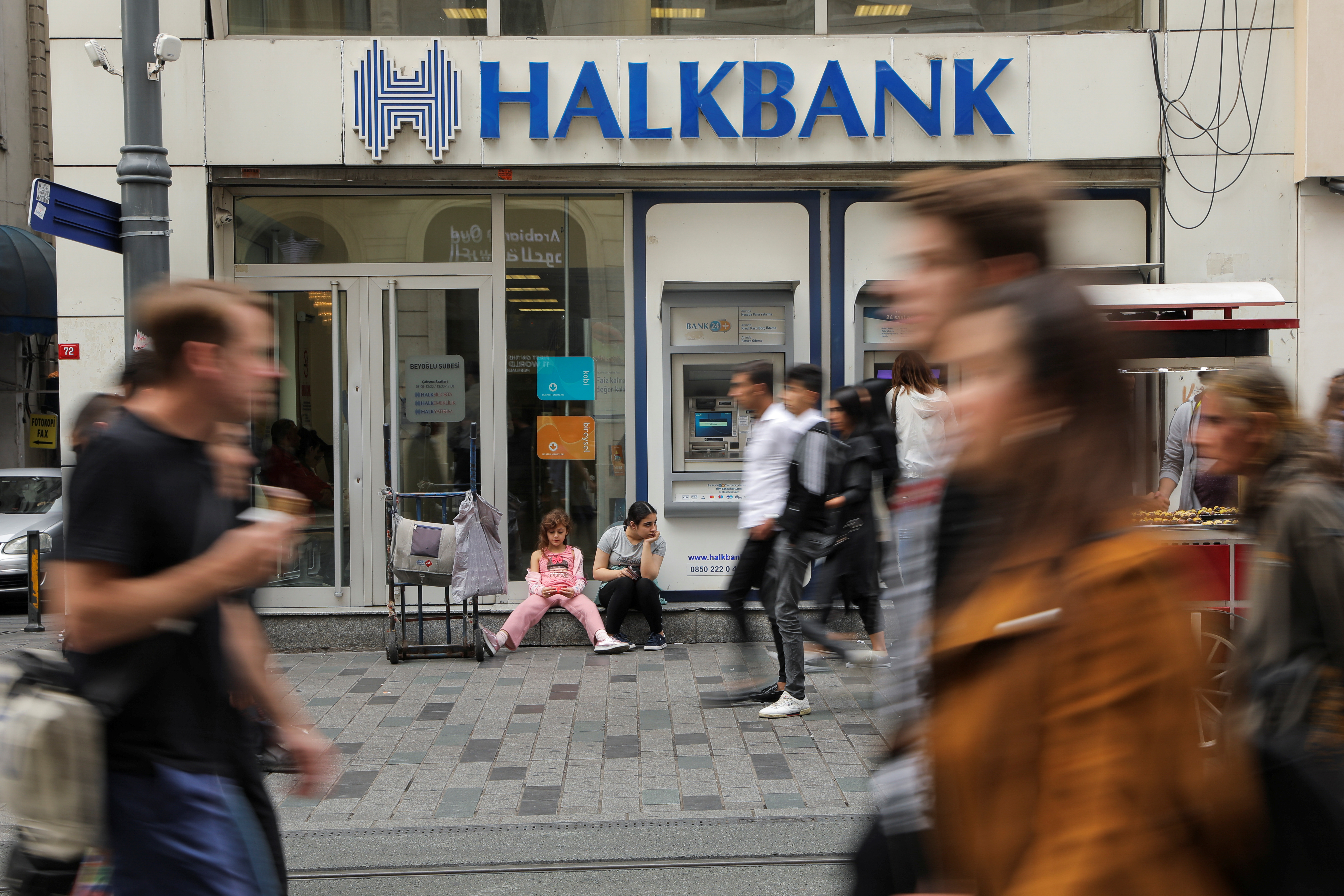 People walk past by a branch of Halkbank in Istanbul