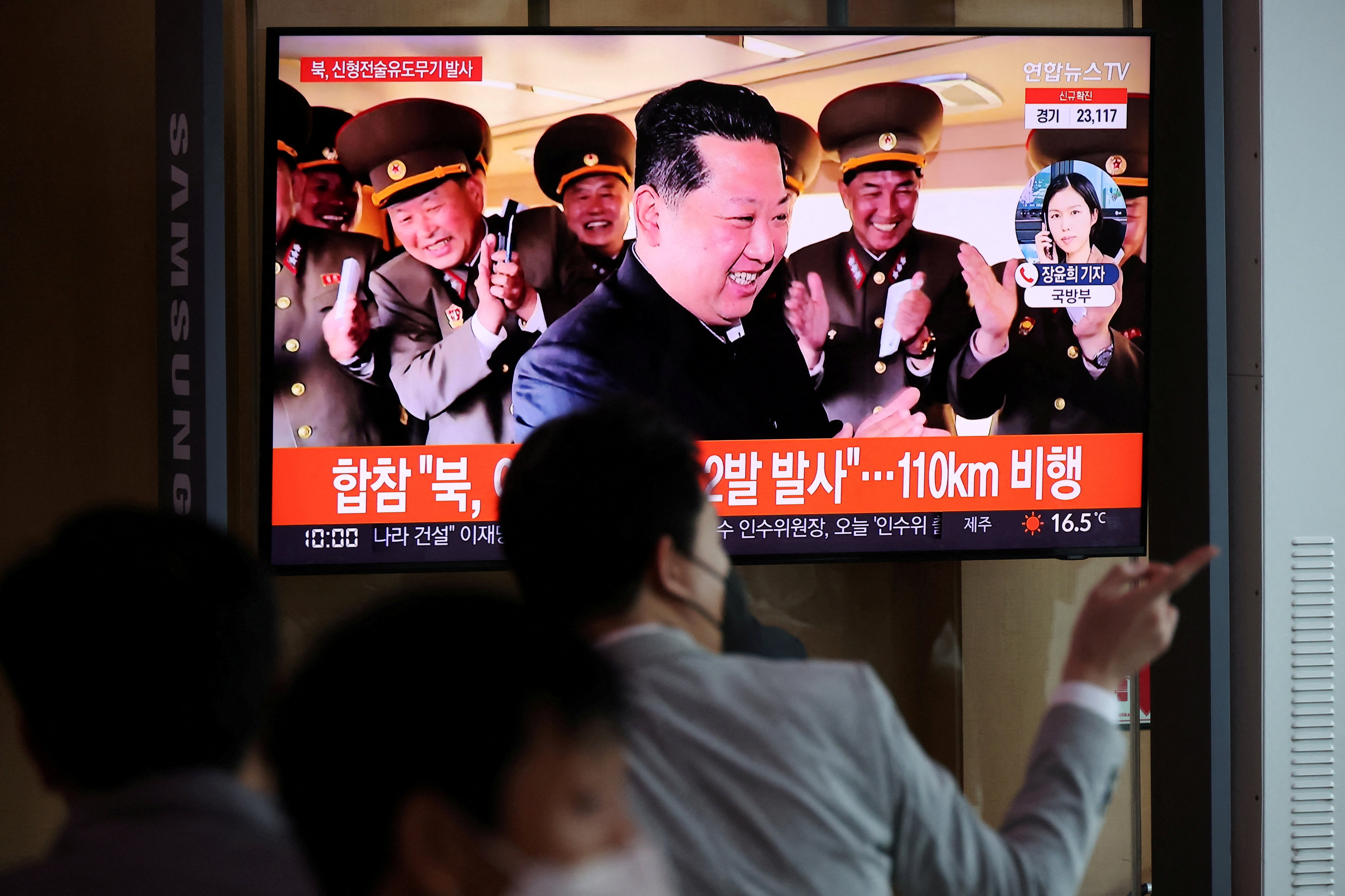 People watch a television broadcasting a news report on North Korea's new type of tactical guided weapon test, at a railway station in Seoul