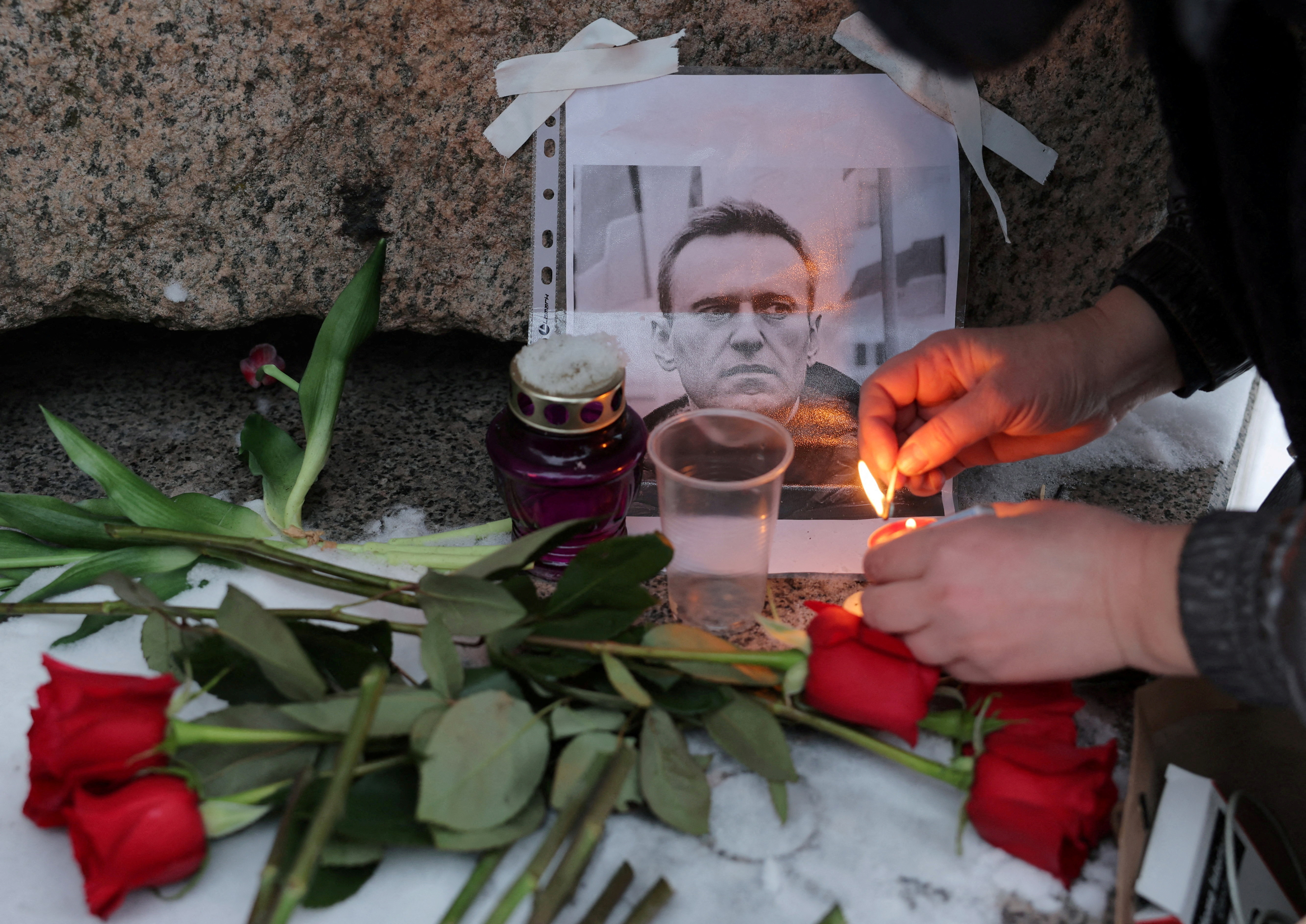 People gather at the monument to the victims of political repressions following the death of Alexei Navalny in Saint Petersburg