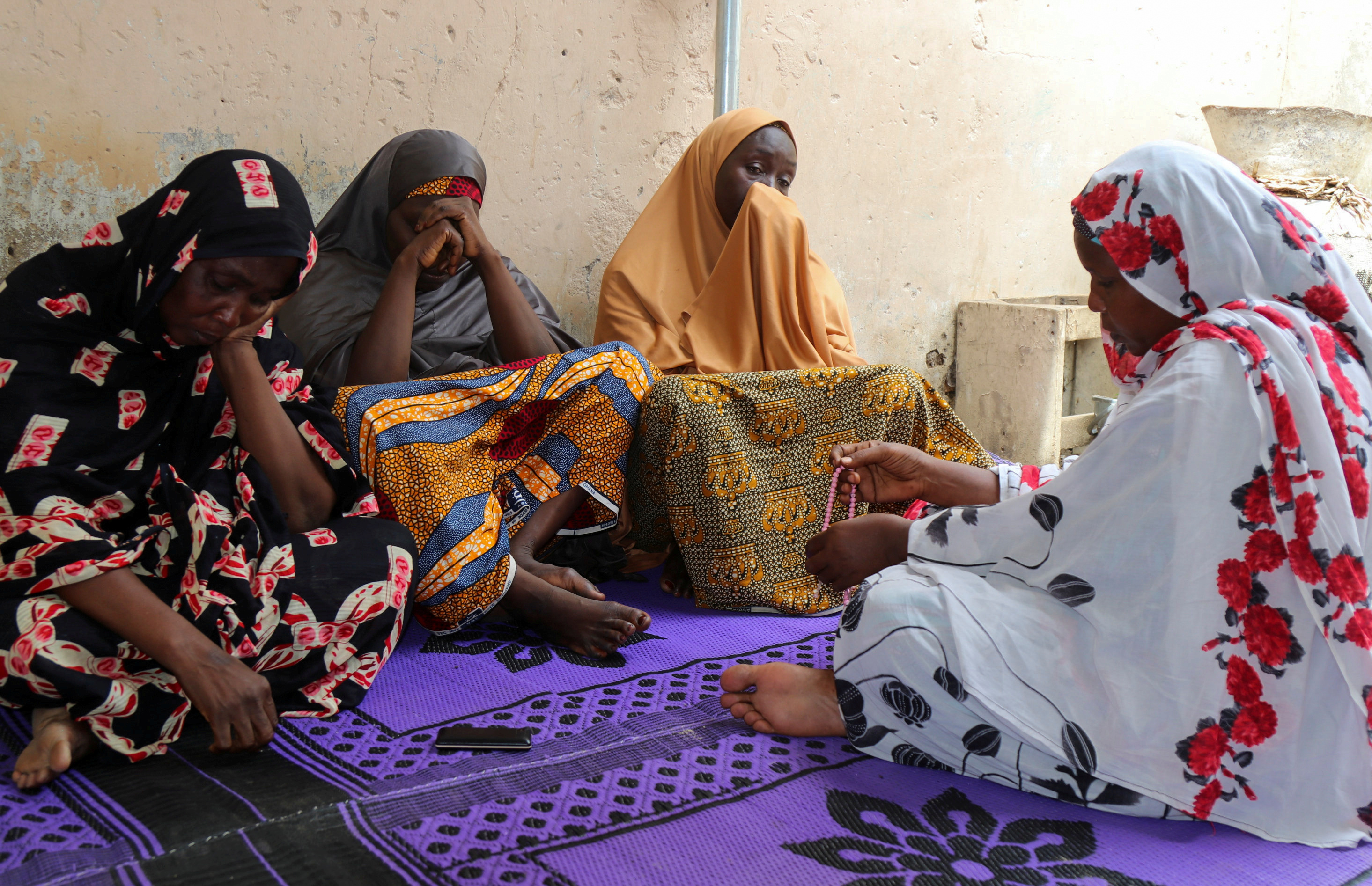 Women mourn the death of one of the aid workers who were executed by Islamist militants, in the northeast Nigerian city of Maiduguri