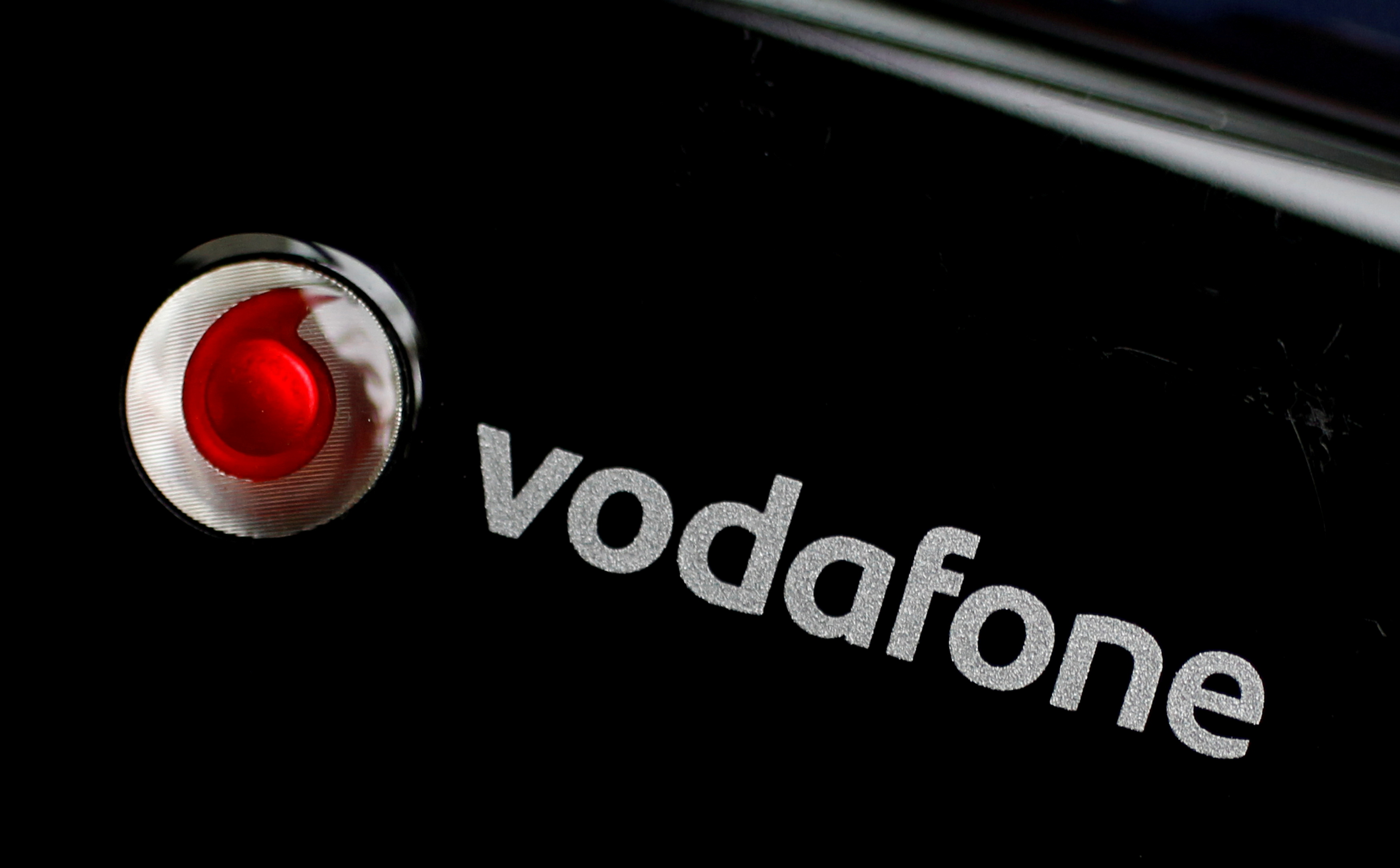 A Vodafone logo is seen on a mobile internet dongle in this photo illustration