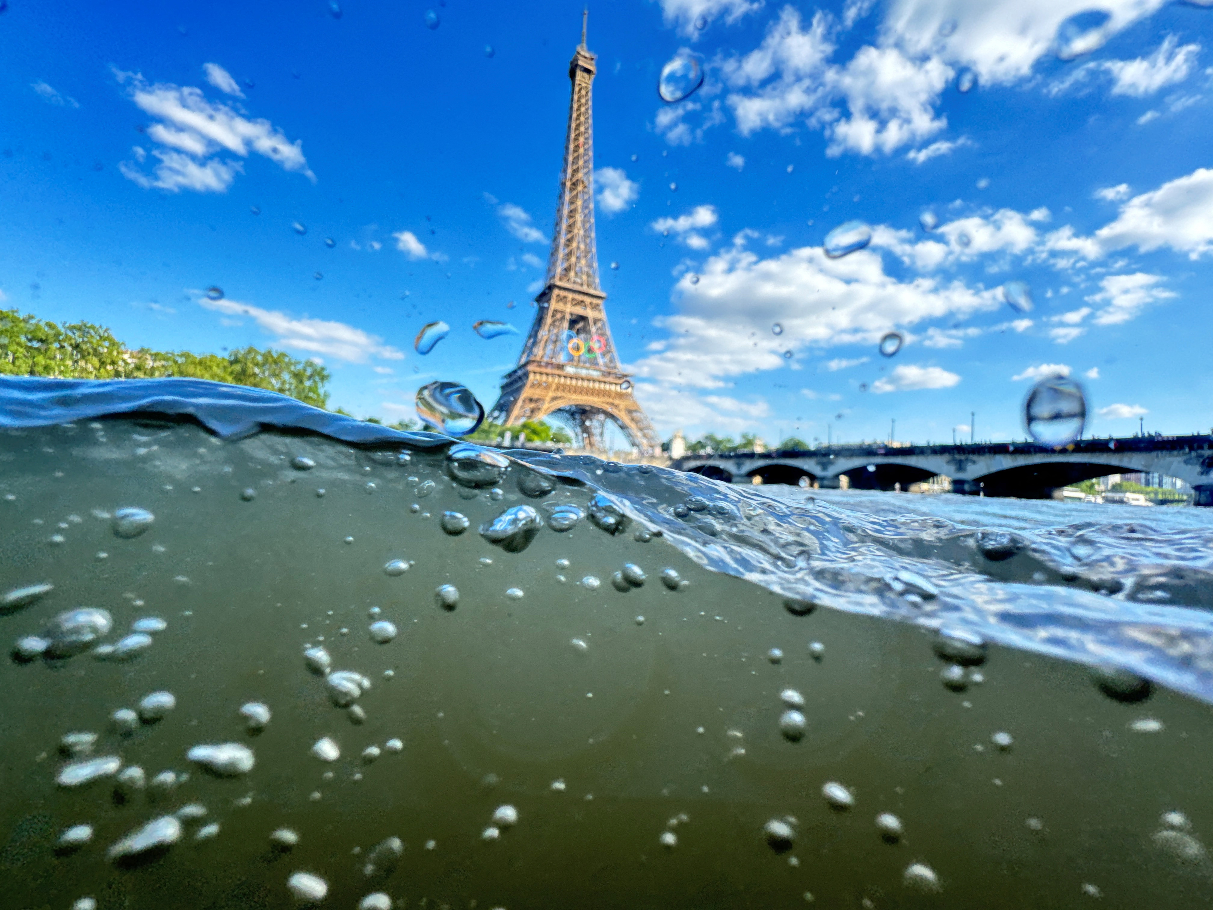 The Eiffel Tower is seen from the water of the Seine River as the Olympics opening ceremony rehearsal is postponed amid rainy weather.
