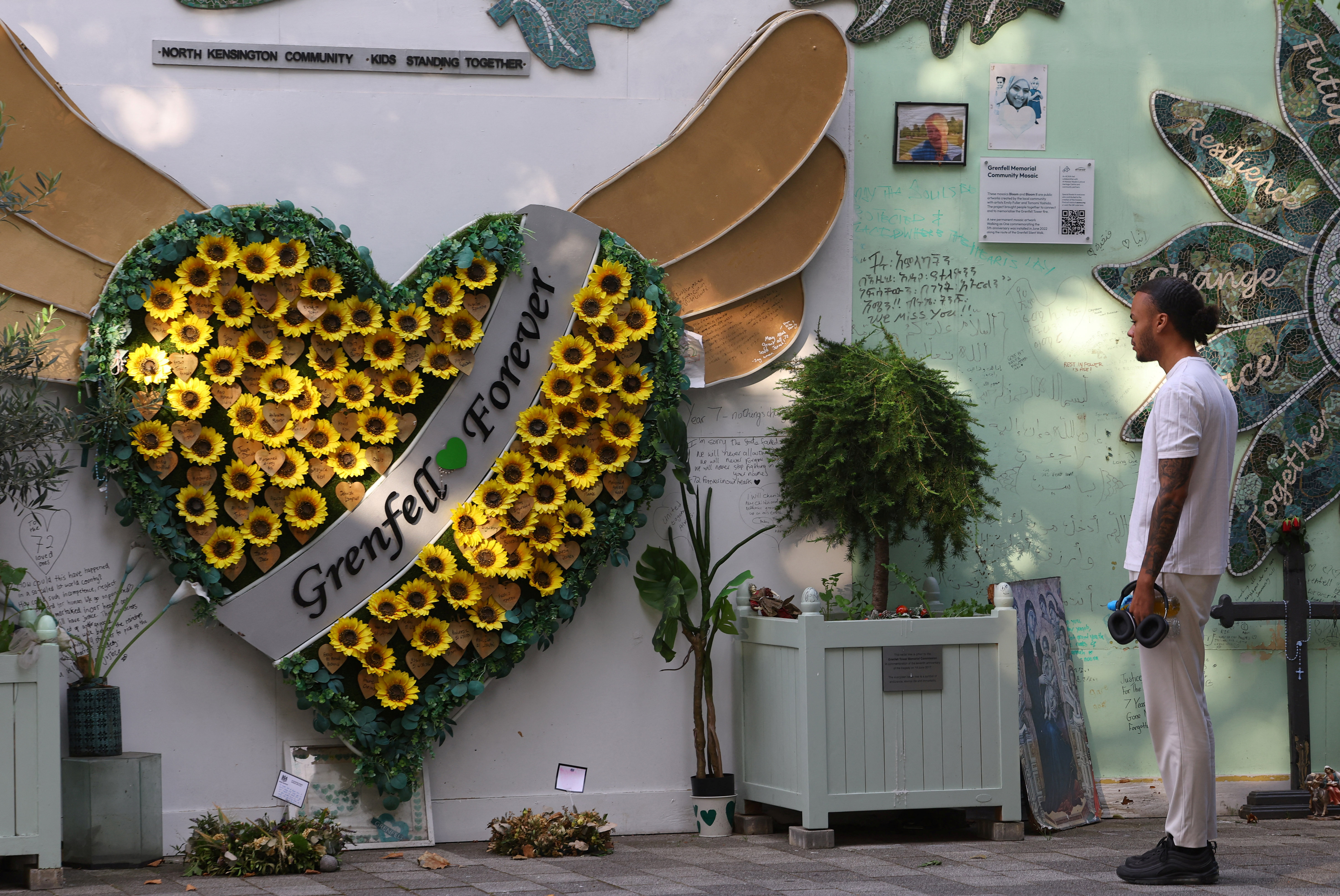 Wall of condolences near to the covered remains of Grenfell Tower, as report from UK public inquiry into the deadly 2017 Grenfell fire published, in London