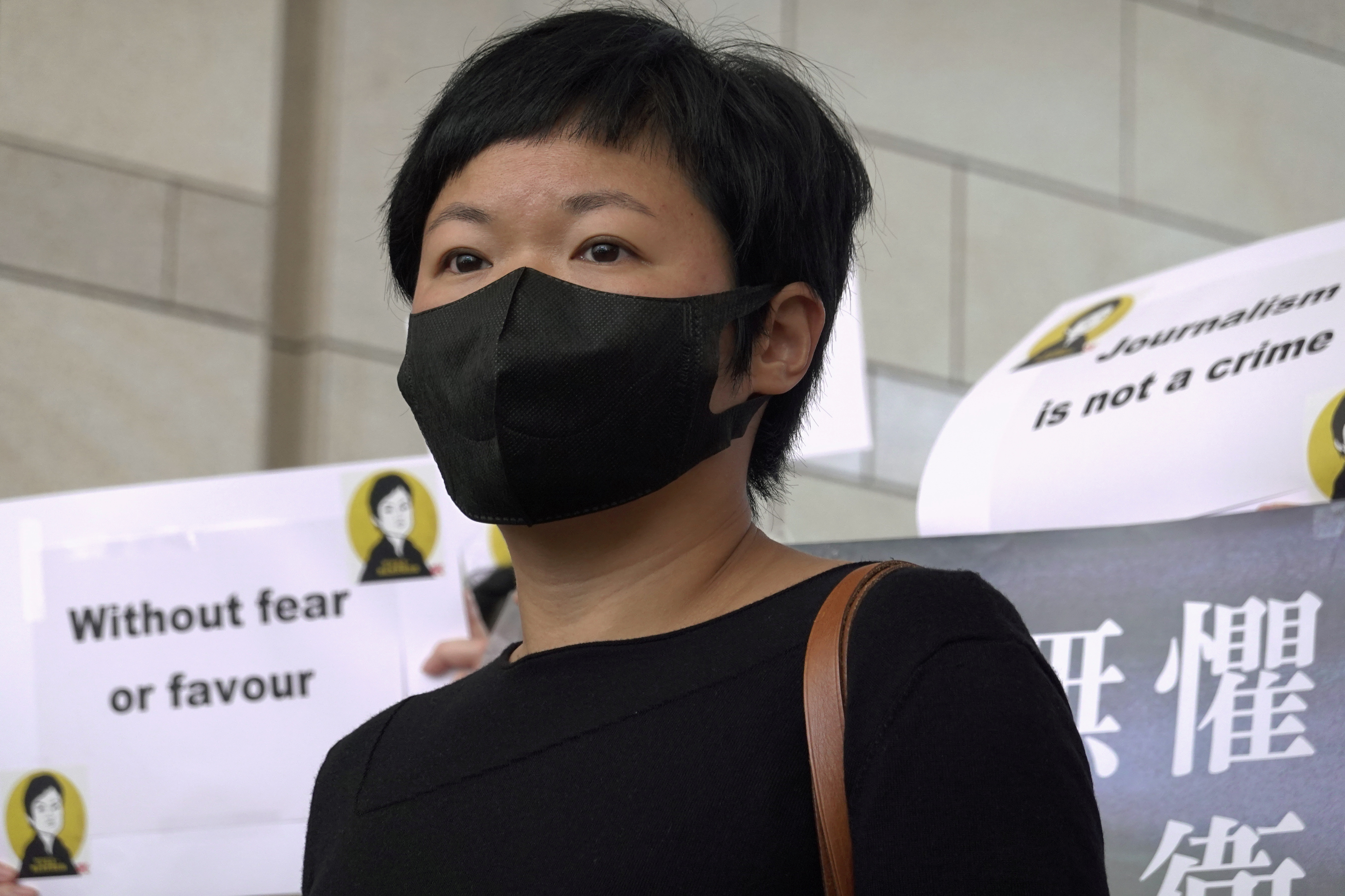 Journalist Bao Choy poses for pictures outside West Kowloon Magistrates' Courts in Hong Kong