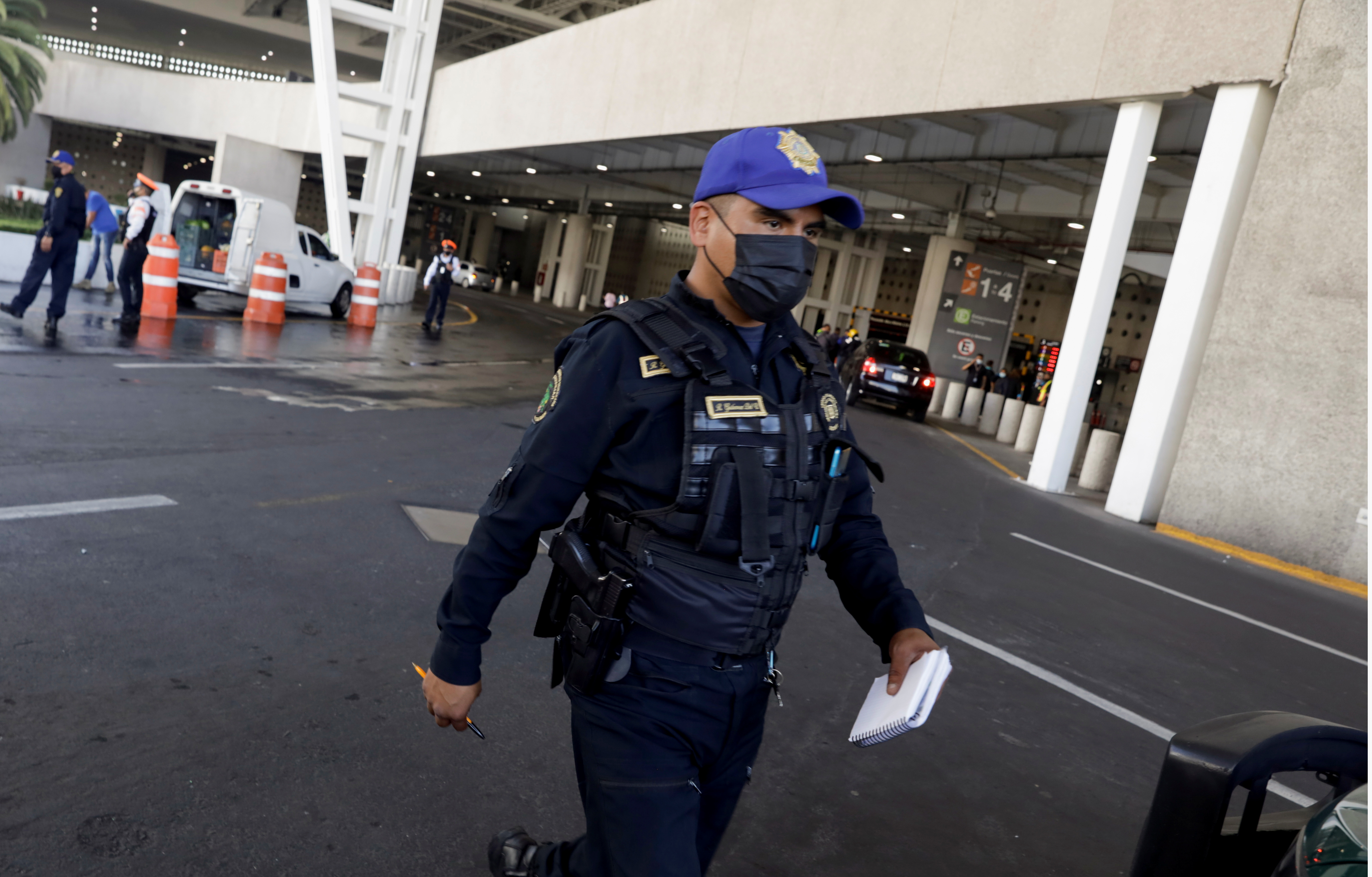 A police officer collects information outside the airport, in Mexico City