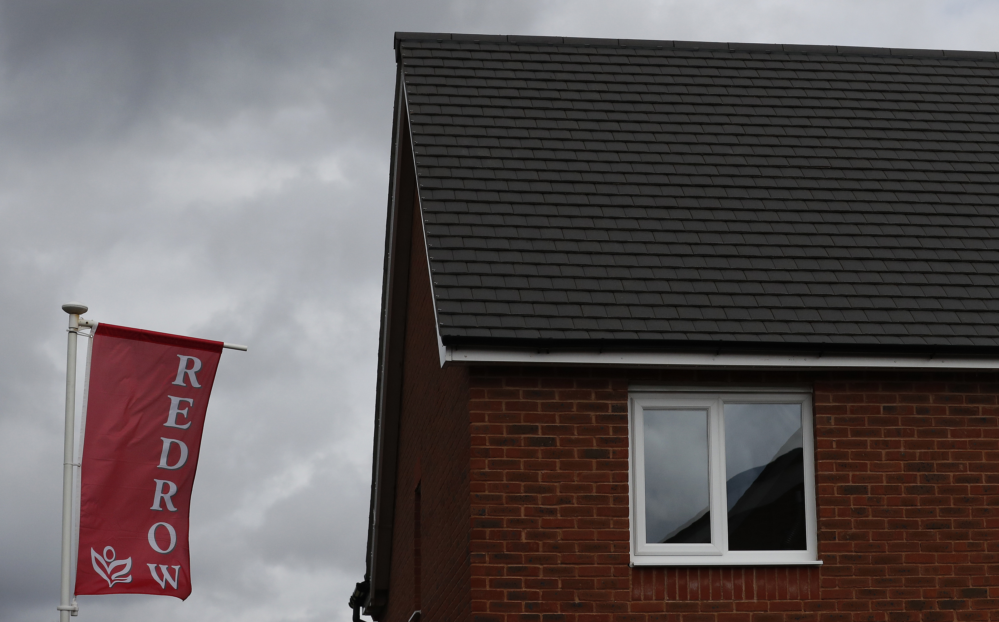 The company logo of construction company Redrow is pictured on a flag at a new housing development near Manchester northern England.