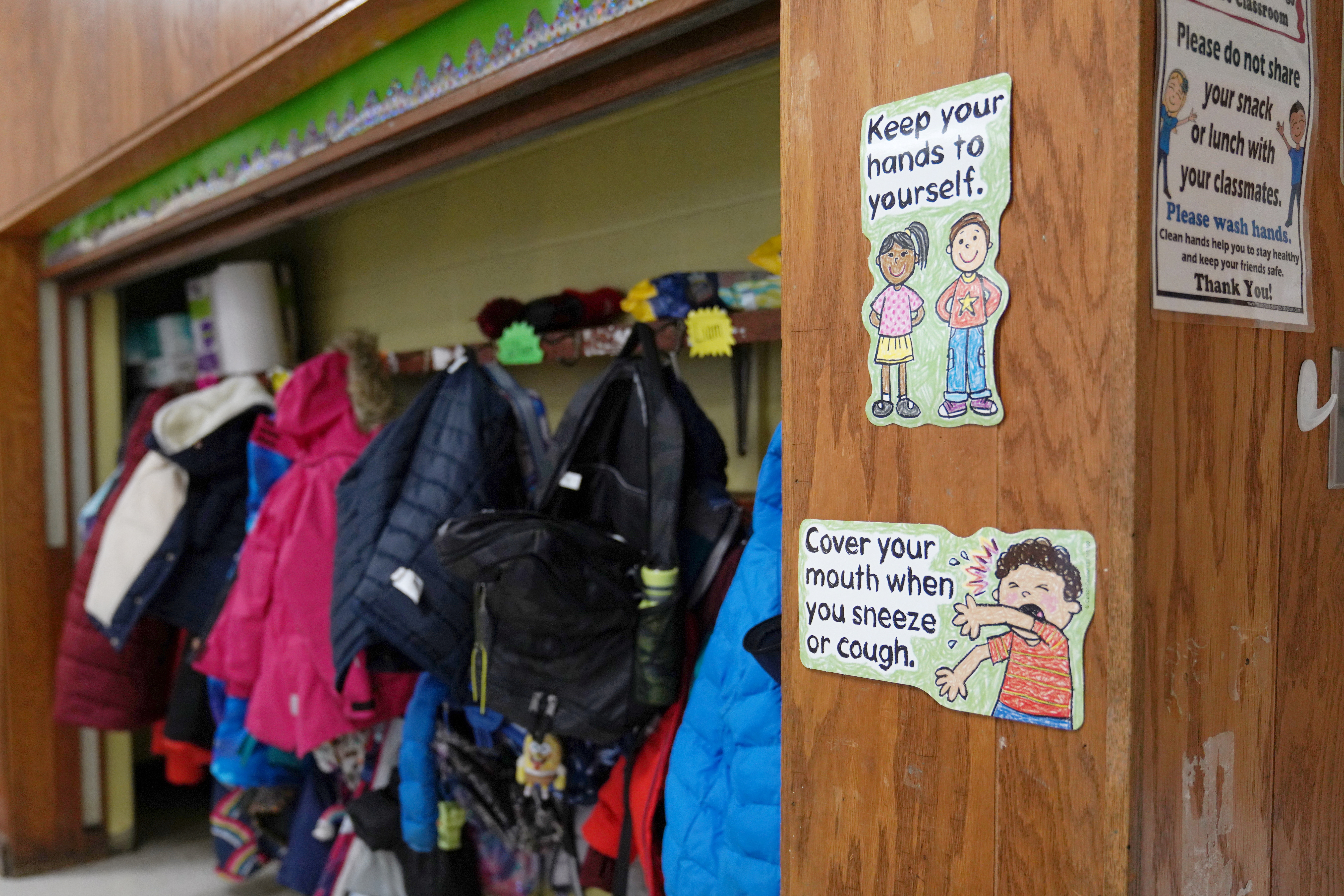 Signs hang to remind children of precautions to prevent the spread of the coronavirus disease (COVID-19) in the classroom at South Boston Catholic Academy in Boston, Massachusetts, U.S., January 28, 2021.  REUTERS/Allison Dinner/File Photo