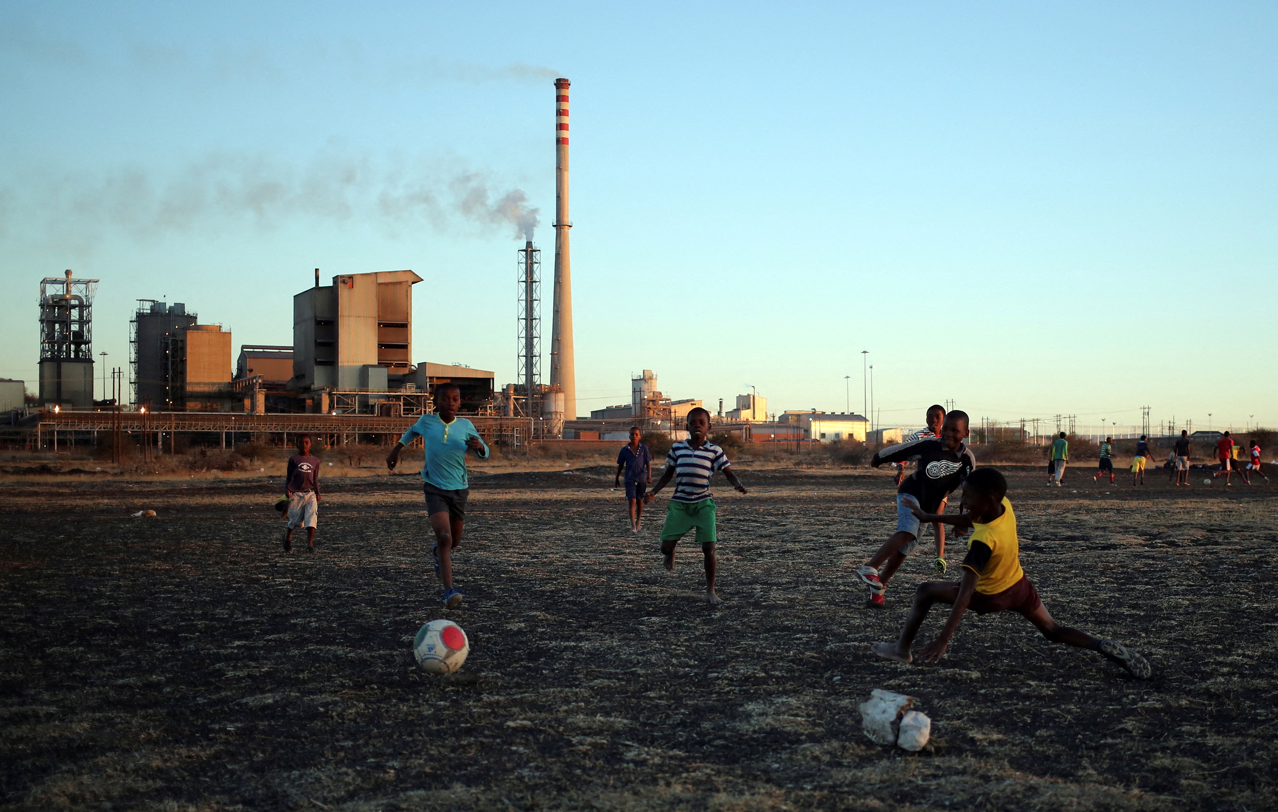 Boys play soccer in Marikana's Nkaneng township in front of the Lonmin's Marikana platinum mine in Rustenburg