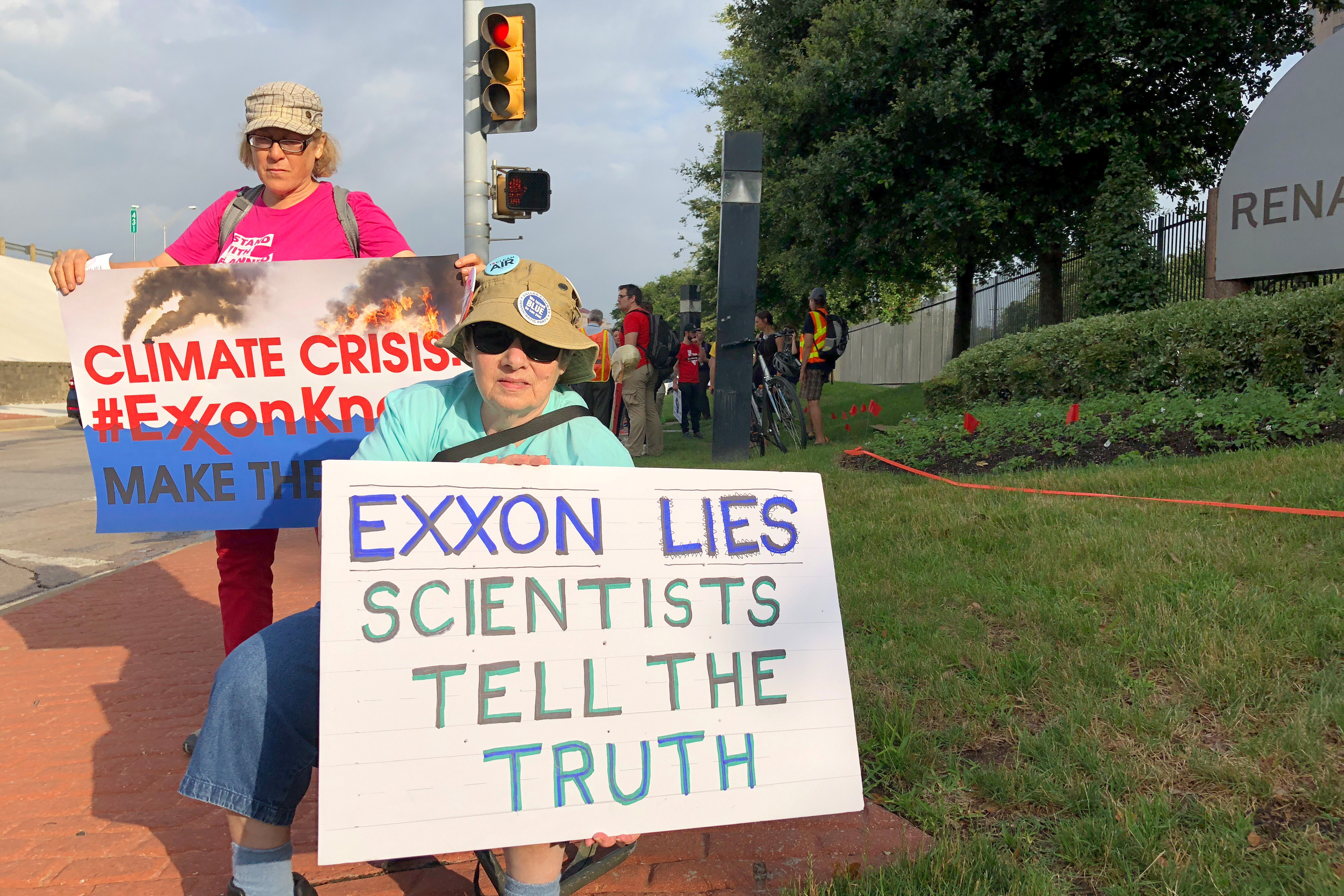 Blanca Gonzales and Susan Cooper protest ExxonMobil's climate change policies as people arrive at the 2019 annual shareholders meeting in Dallas