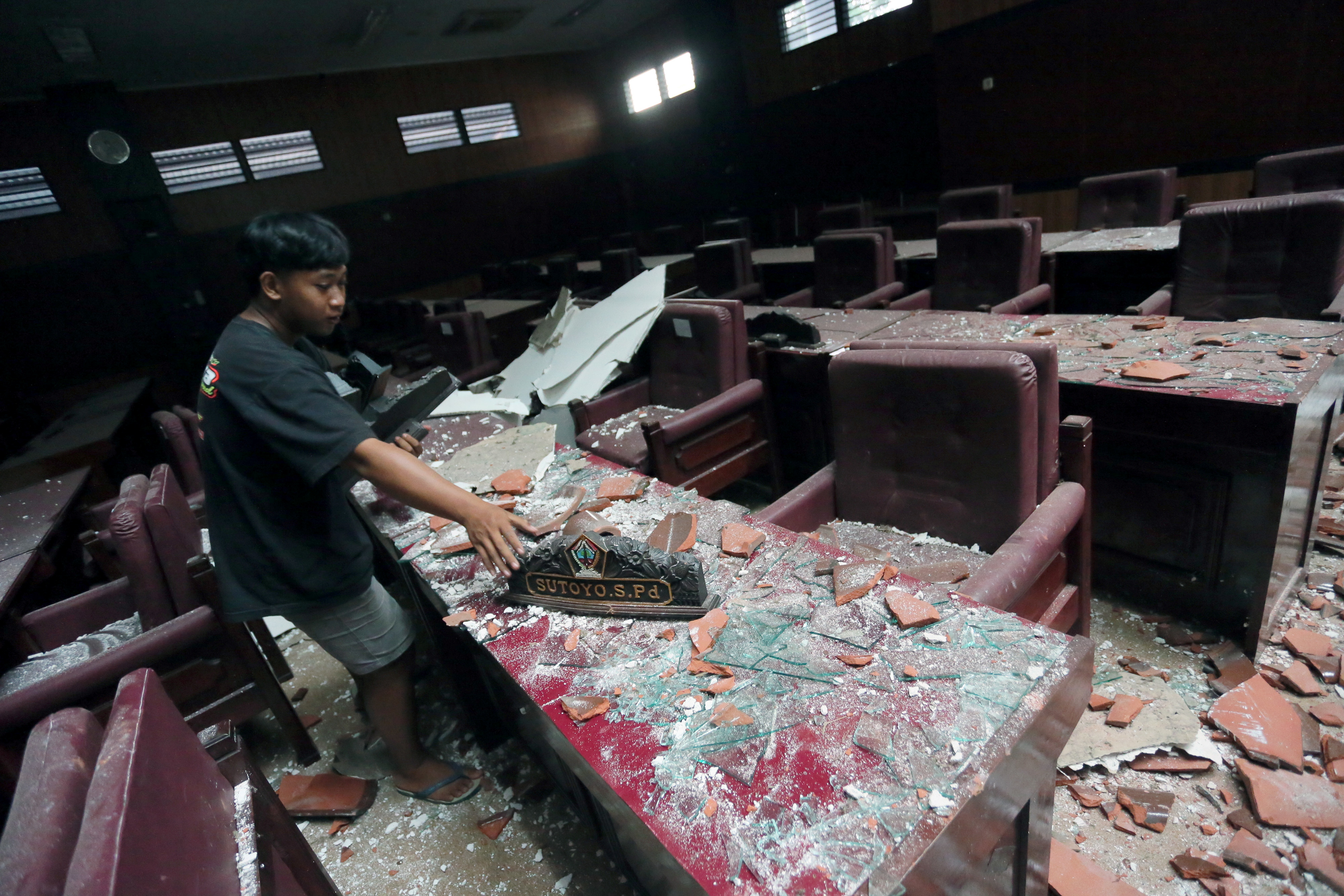 A man cleans up a damaged courtroom affected by an earthquake of magnitude 5.9 struck in the ocean 91 km (57 miles) south-southeast of Blitar