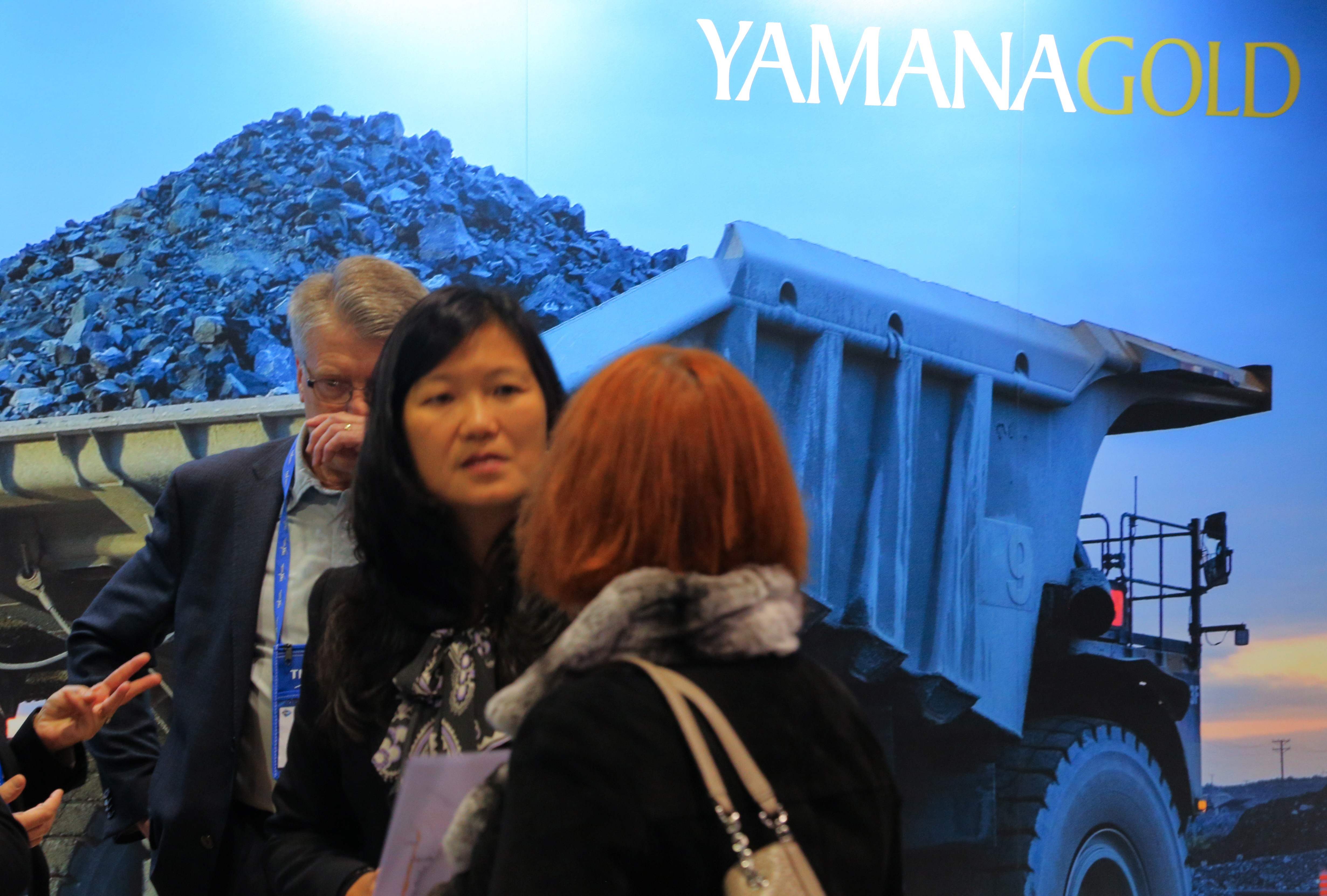 Visitors to the Yamana Gold mining company booth speak with representatives during the PDAC convention in Toronto