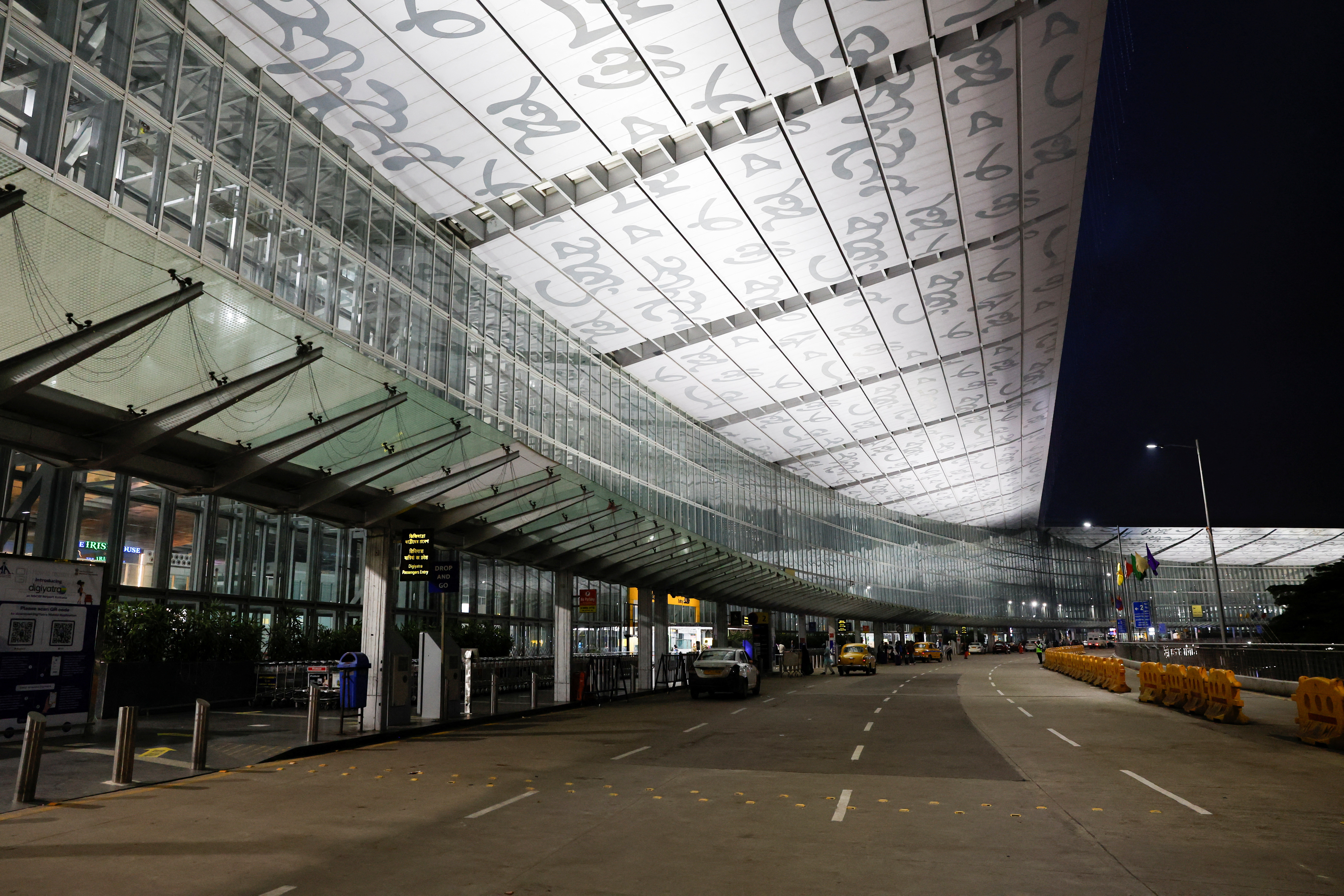 Taxis are parked outside the departure gates of the deserted Netaji Subhas Chandra Bose International Airport after flights were cancelled in preparations ahead of cyclone Dana in Kolkata