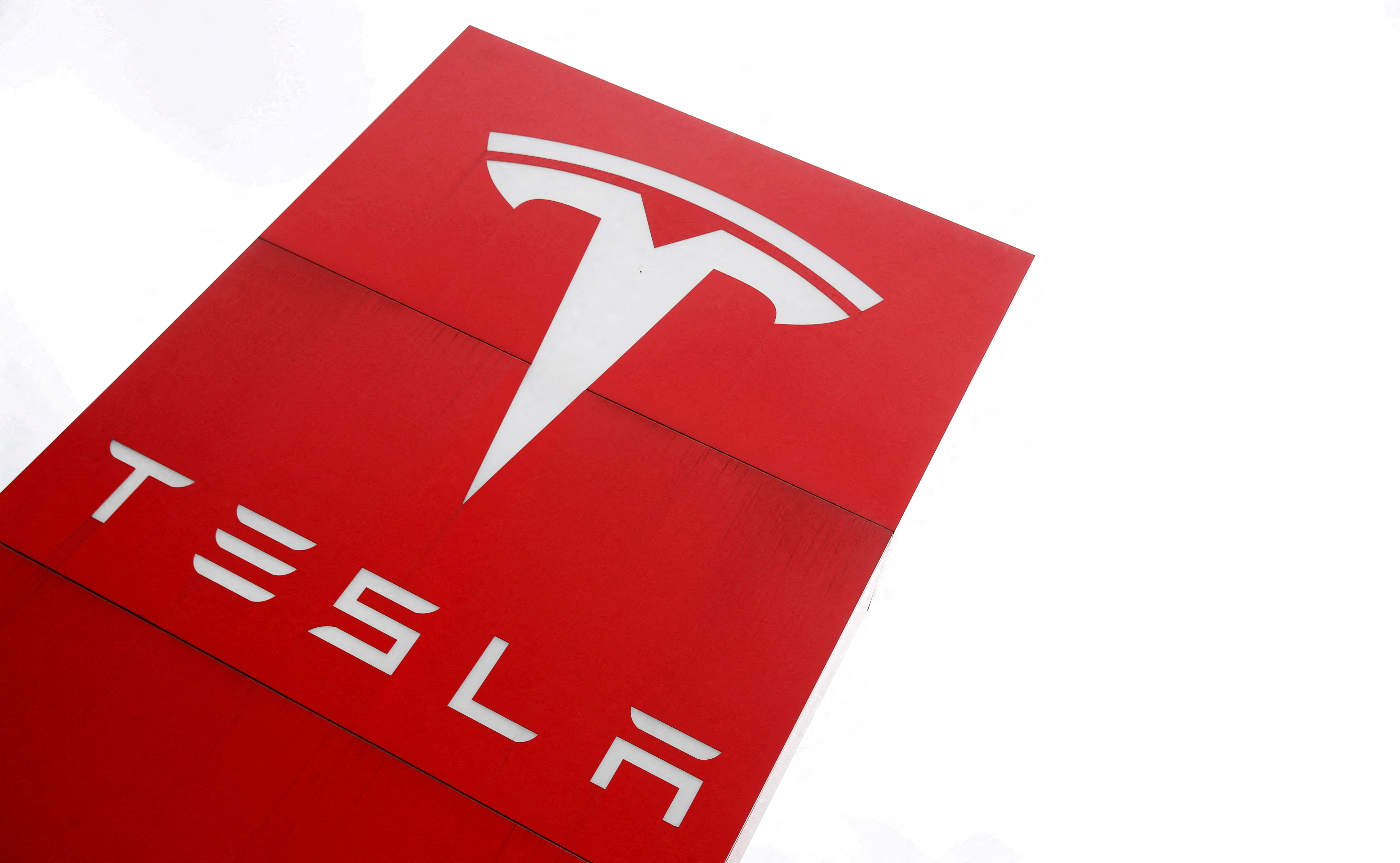 The logo of car manufacturer Tesla is seen at a dealership in London, Britain, May 14, 2021. REUTERS/Matthew Childs/File Photo