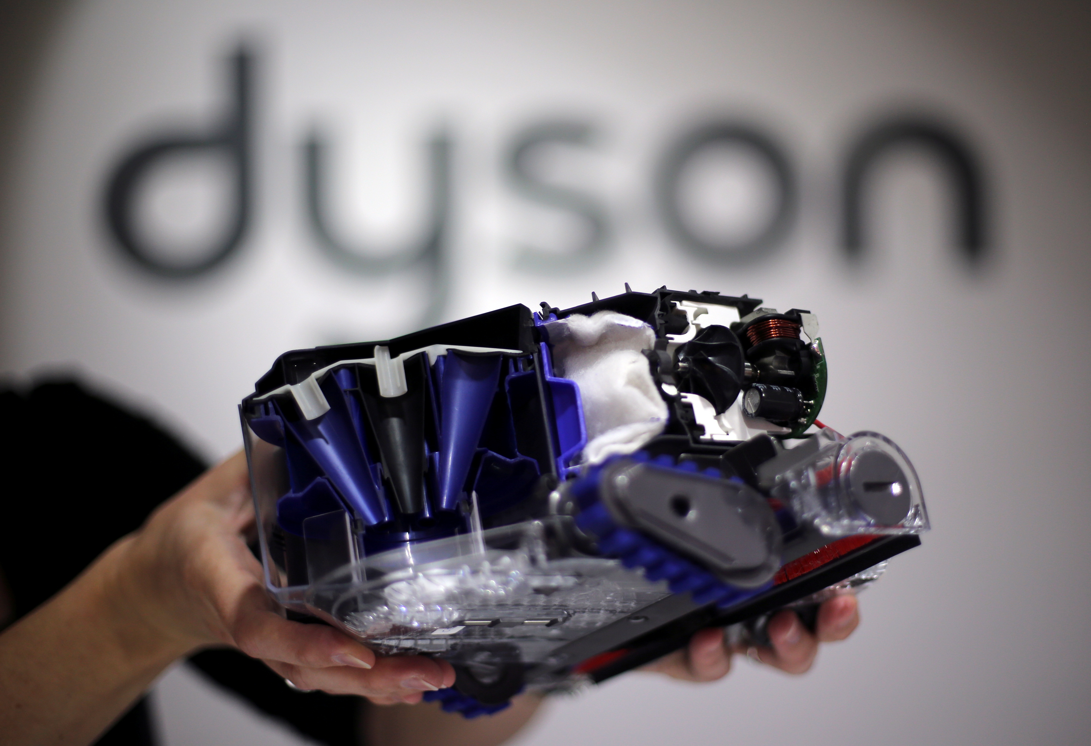 A Dyson employee shows a Dyson 360 Eye robot vacuum cleaner without its cover during the IFA Electronics show in Berlin