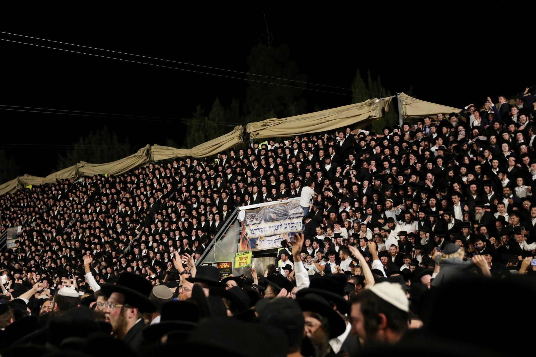 Jewish worshippers sing and dance as they stand on tribunes at the Lag B'Omer event in Mount Meron, northern Israel, April 29, 2021. REUTERS/ Stringer 