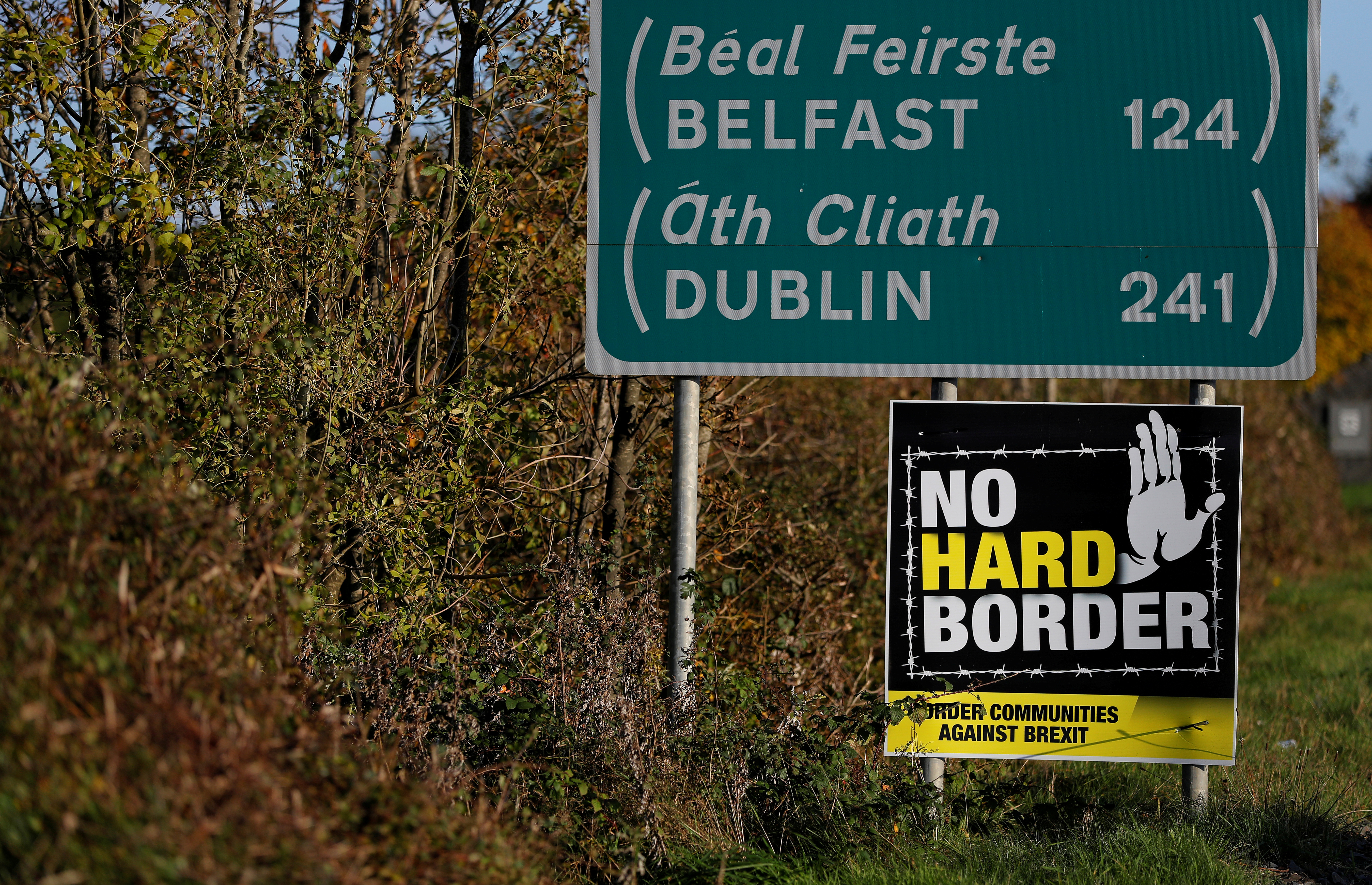 A 'No Hard Border' poster is seen below a road sign on the Irish side of the border between Ireland and Northern Ireland near Bridgend