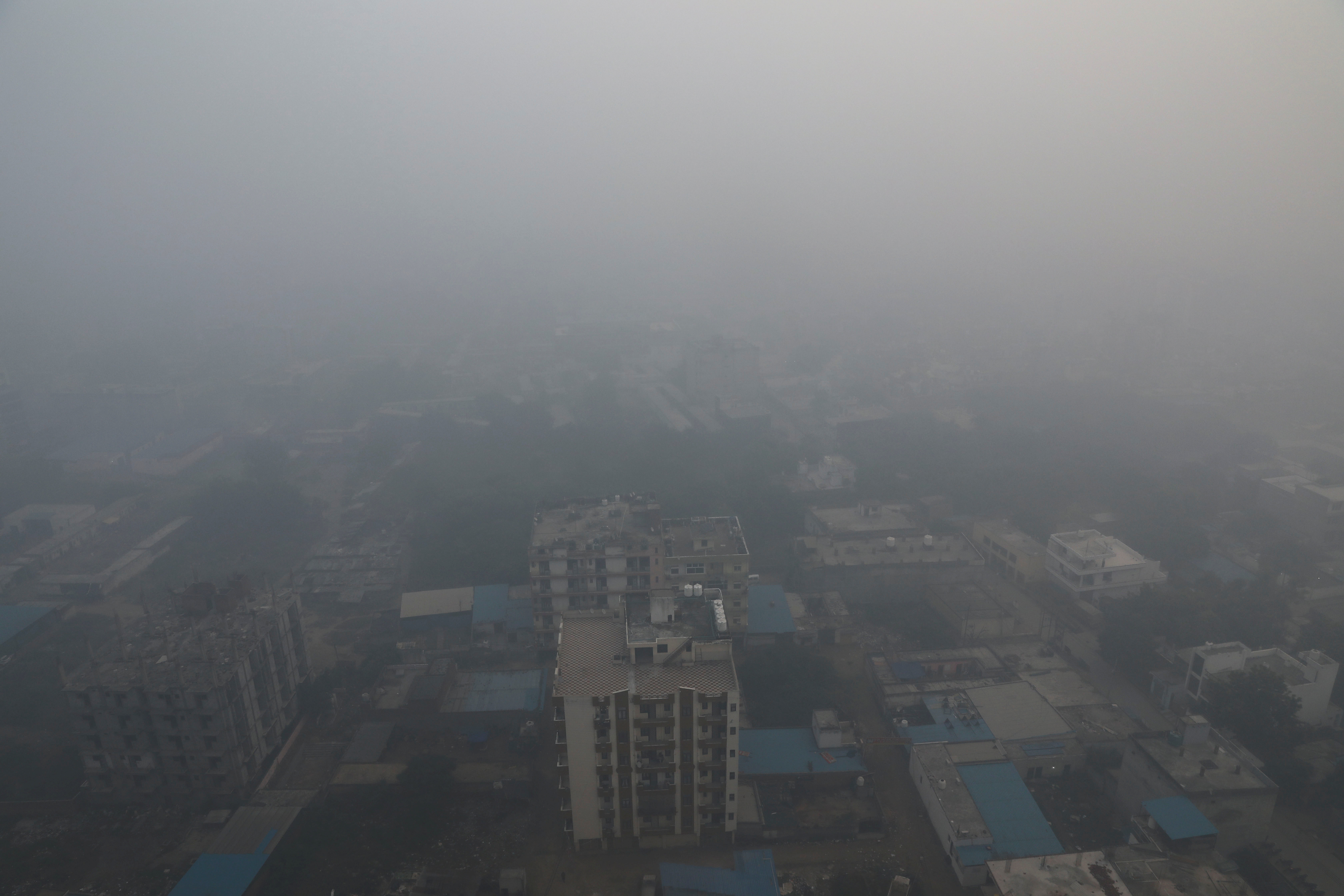 Residential buildings are seen shrouded in smog in Noida, India, November 5, 2021. REUTERS/Anushree Fadnavis