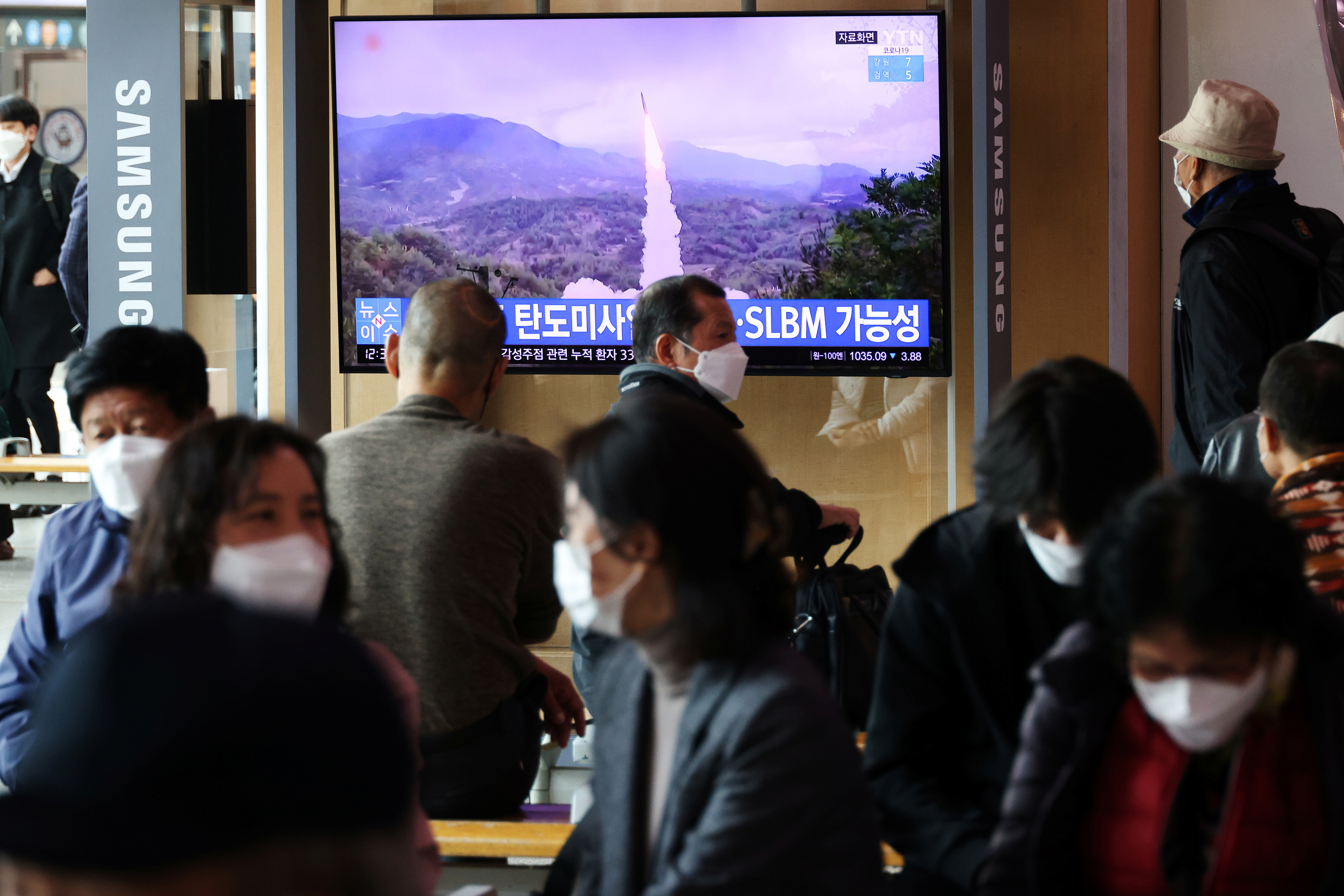 People watch a TV broadcasting file footage of a news report on North Korea firing a ballistic missile off its east coast, in Seoul