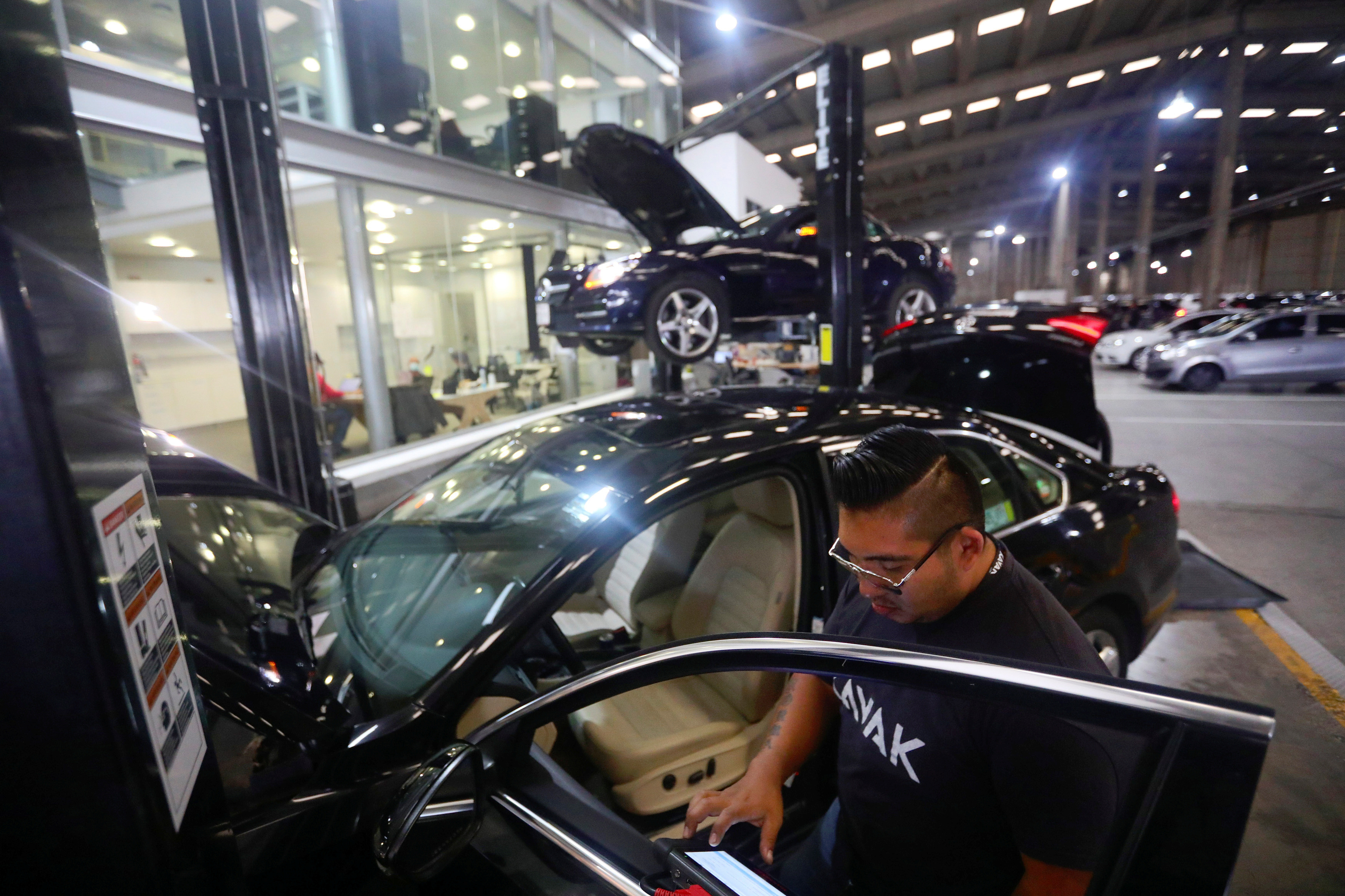 An employee checks a car at used autos platform Kavak in Mexico City