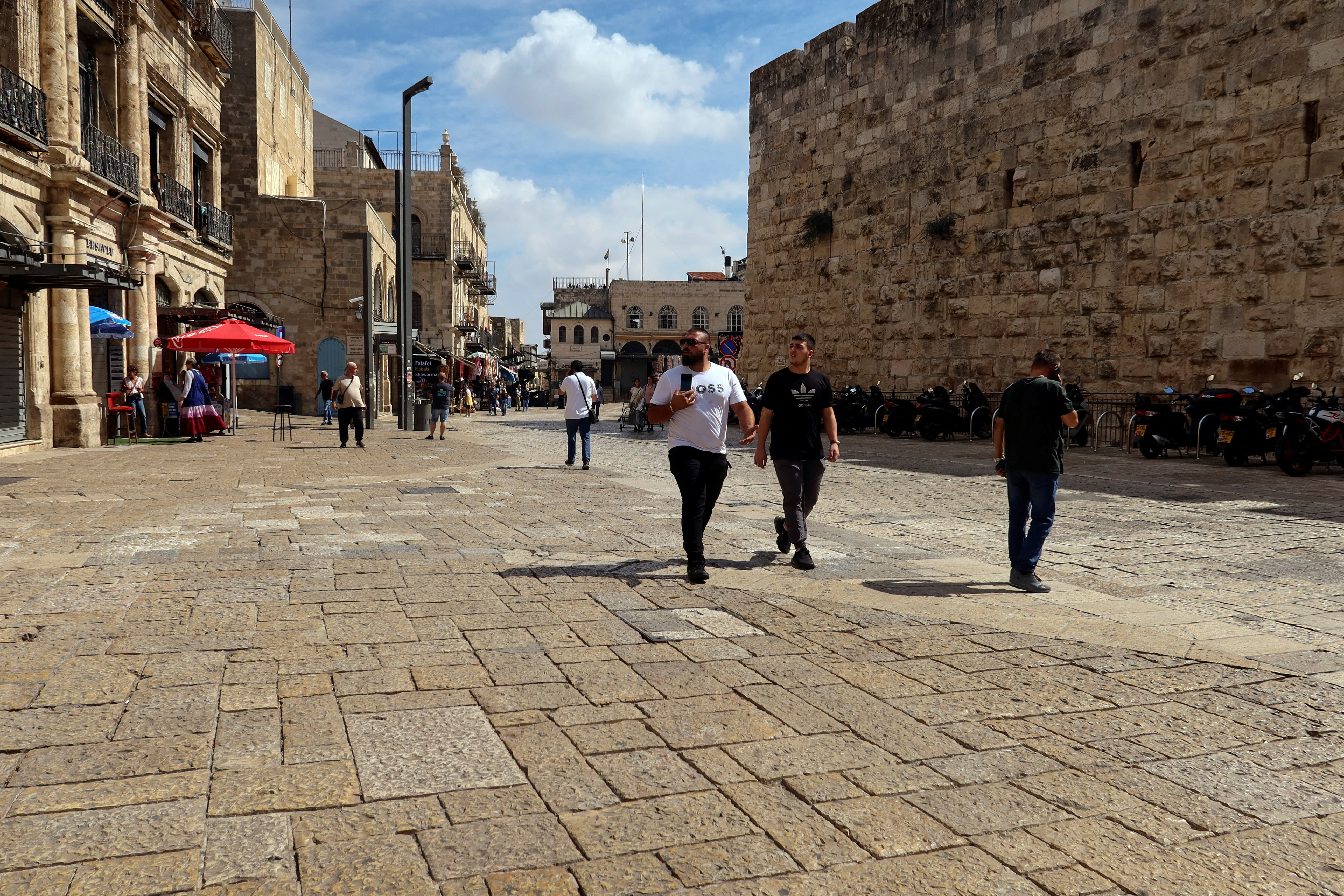 People walk into Jerusalem's Old City via Jaffa Gate, as the conflict wreaks havoc across the tourism sector