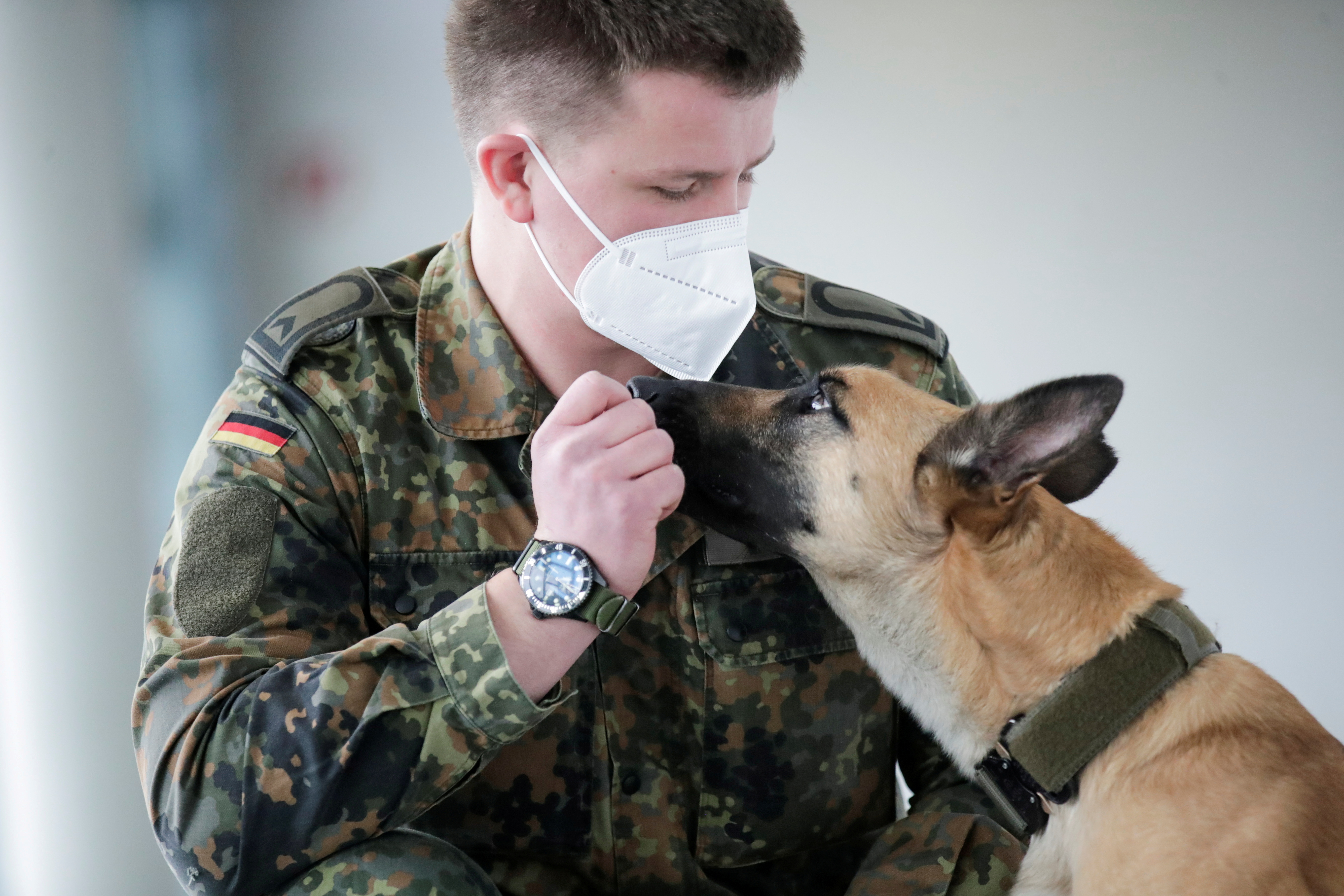 A member of a military poses with Filou, the 3-year-old Belgian shepherd which is able to detect COVID-19 in humans' saliva samples, in Hanover, Germany, February 3, 2021. REUTERS/Hannibal Hanschke