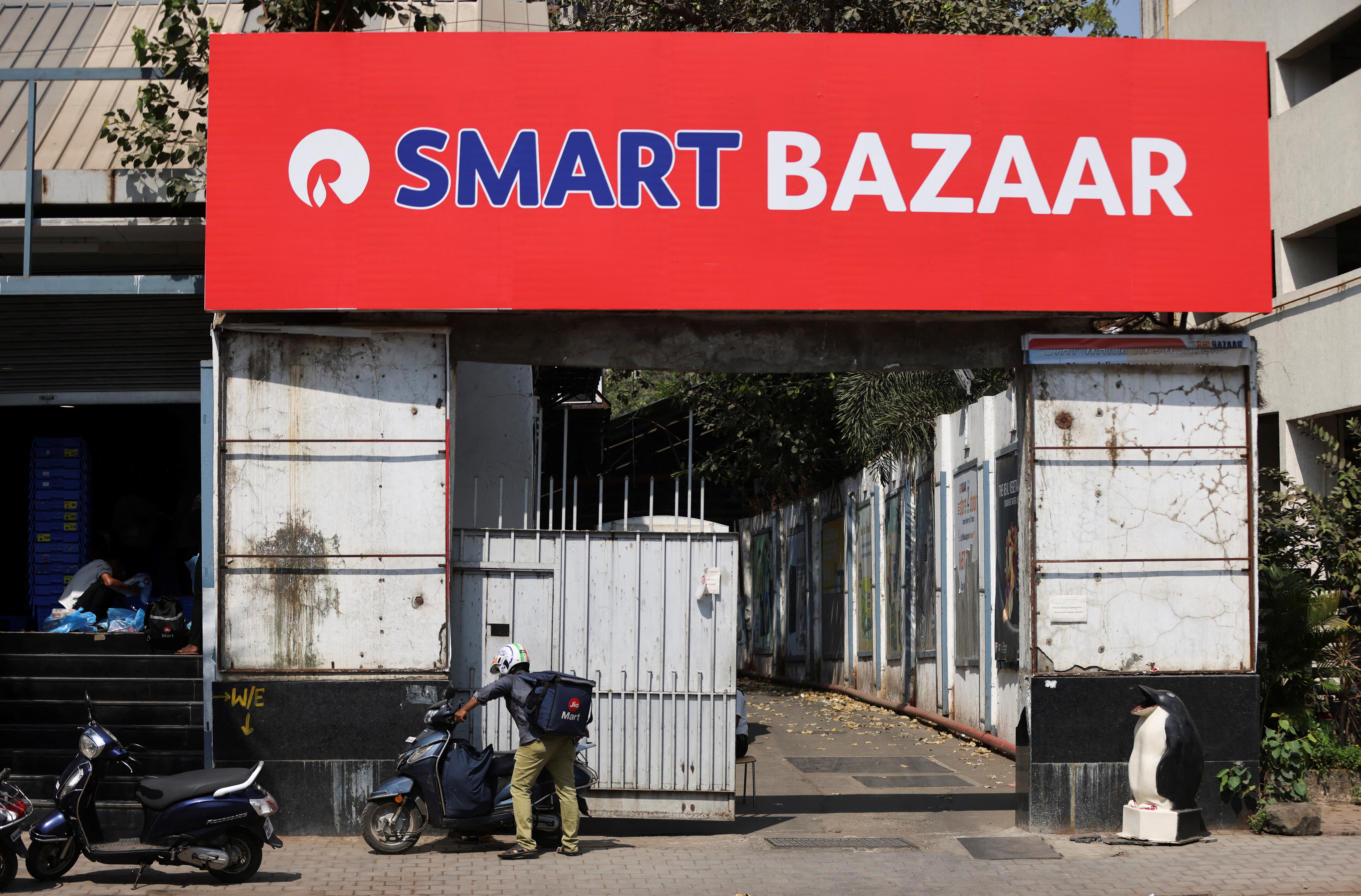 A delivery boy parks his scooter outside a Reliance Smart Bazaar retail store, which was previously Future Retail's Big Bazaar outlet in Mumbai
