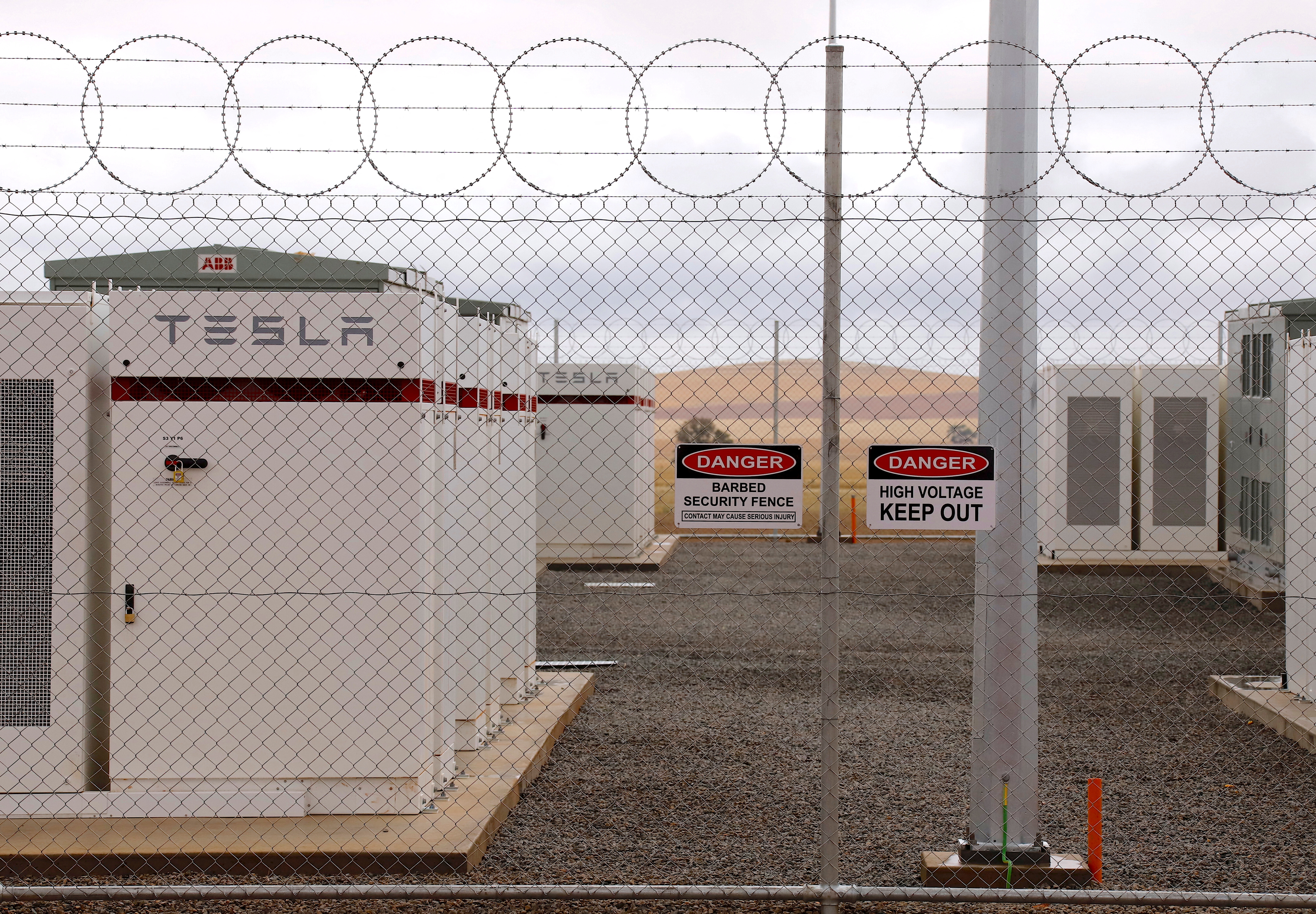 Warning signs adorn the fence surrounding the compound housing the Hornsdale Power Reserve, featuring a lithium-ion battery made by Tesla, near the South Australian town of Jamestown
