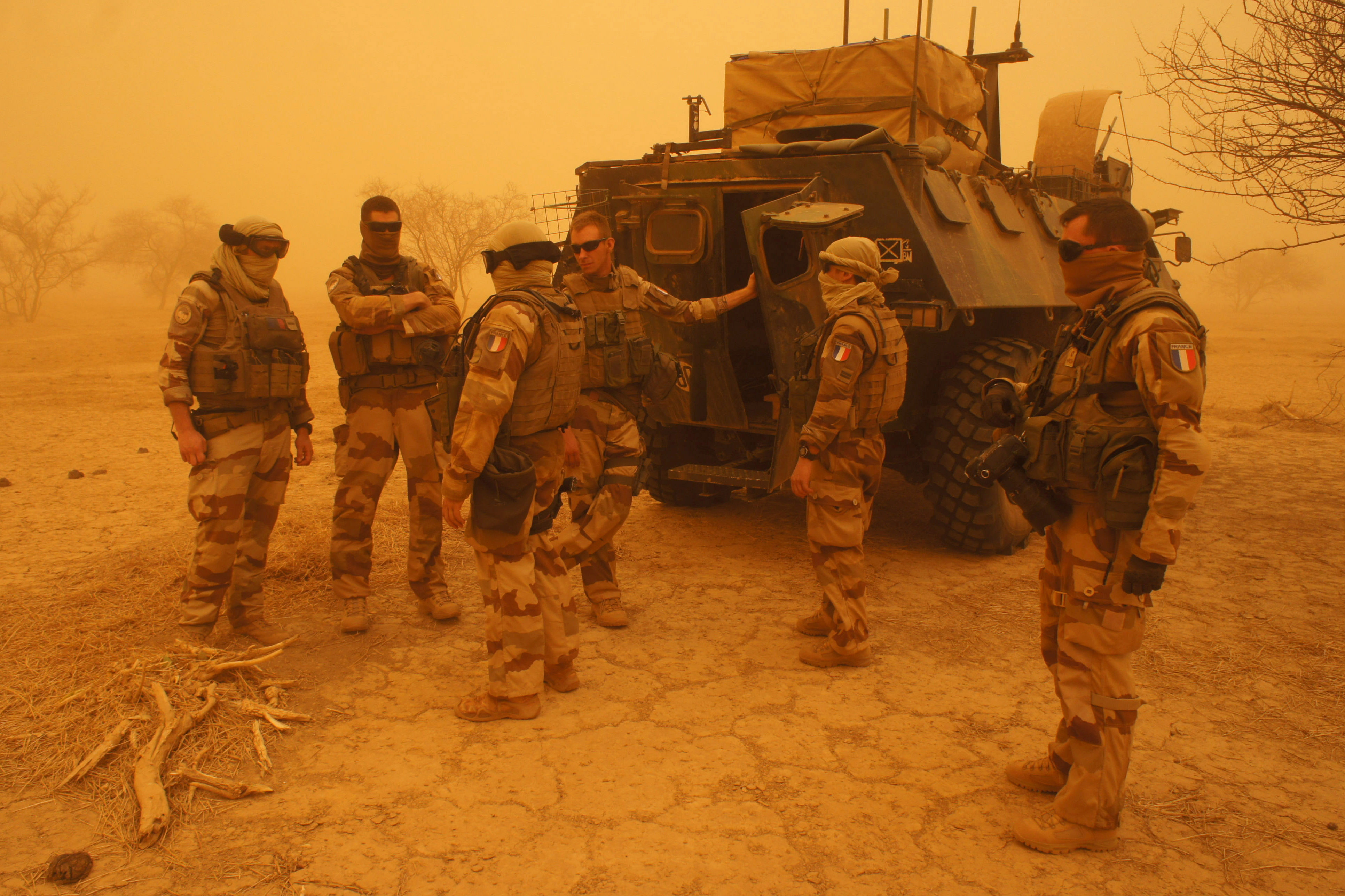 French soldiers from Operation Barkhane stand outside their armored personnel carrier during a sandstorm in Inat