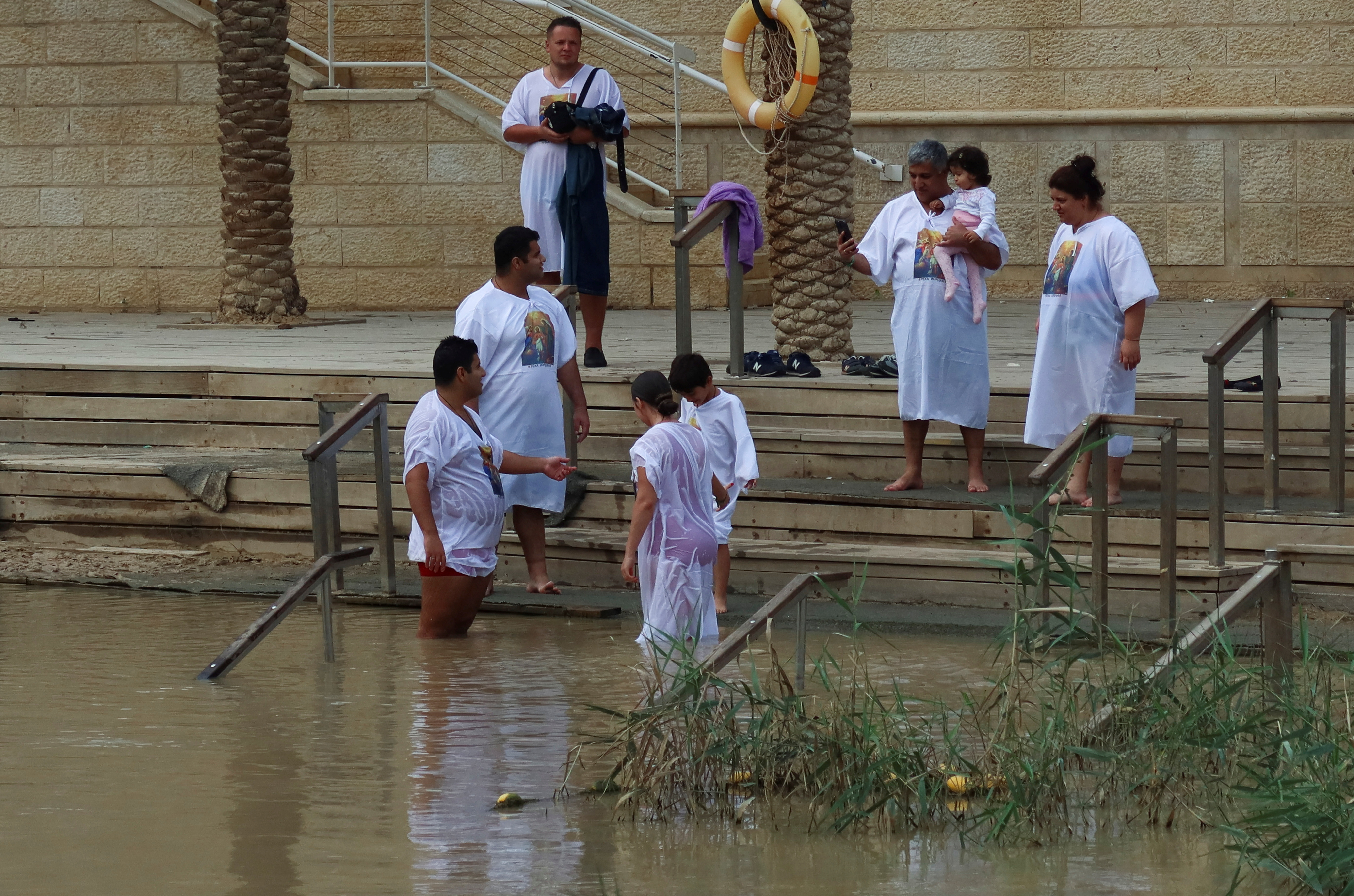 People dip themselves in Jordan River at the Qasr el-Yahud site, near Jericho, in the Israeli-occupied West Bank, as pictured from the Jordan Valley