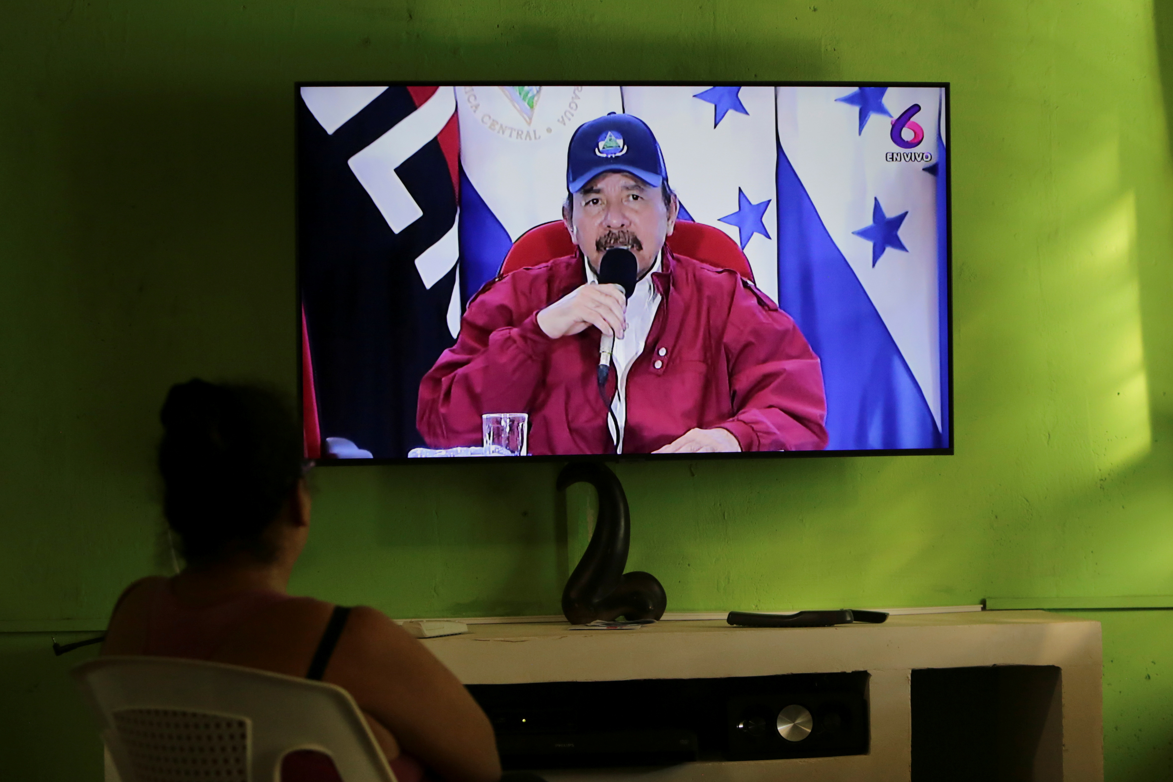 A woman watches a televised speech by Nicaraguan President Daniel Ortega during an event where he agreed with his Honduran counterpart Juan Orlando Hernandez to define their borders in the Caribbean Sea and the Pacific Ocean, including the Gulf of Fonseca, which they share with El Salvador, in Managua, Nicaragua October 27, 2021. REUTERS/Maynor Valenzuela/File Photo
