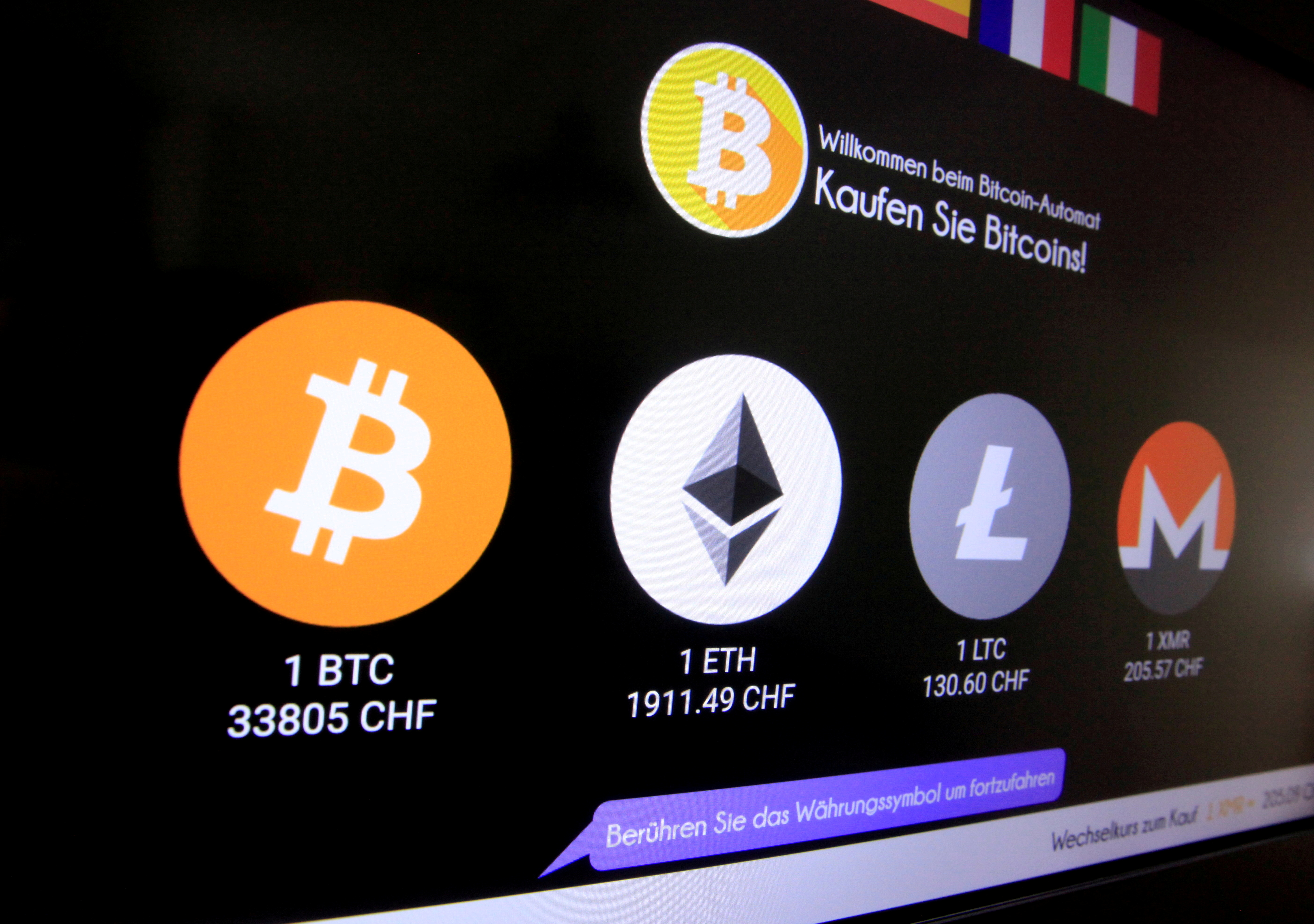 Exchange rates and logos of Bitcoin, Ether, Litecoin and Monero are seen on a cryptocurrency ATM in Zurich