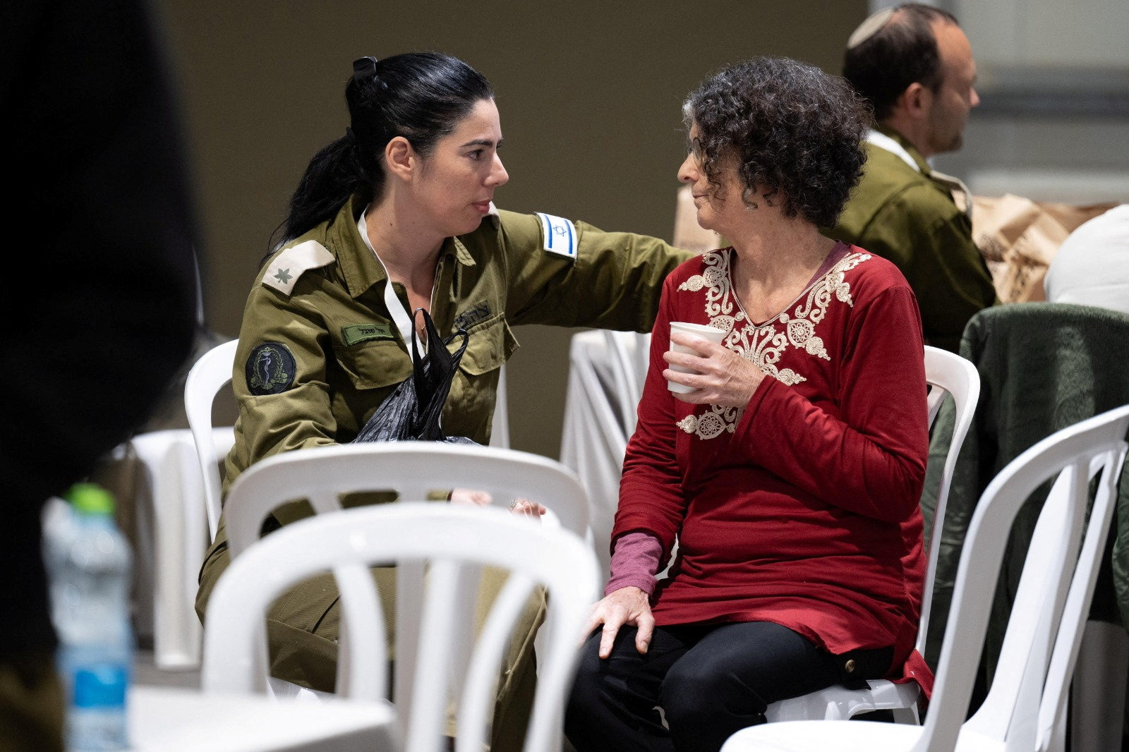 Shoshan Haran, a released Israeli hostage, speaks with an Israeli soldier shortly after her arrival in Israel