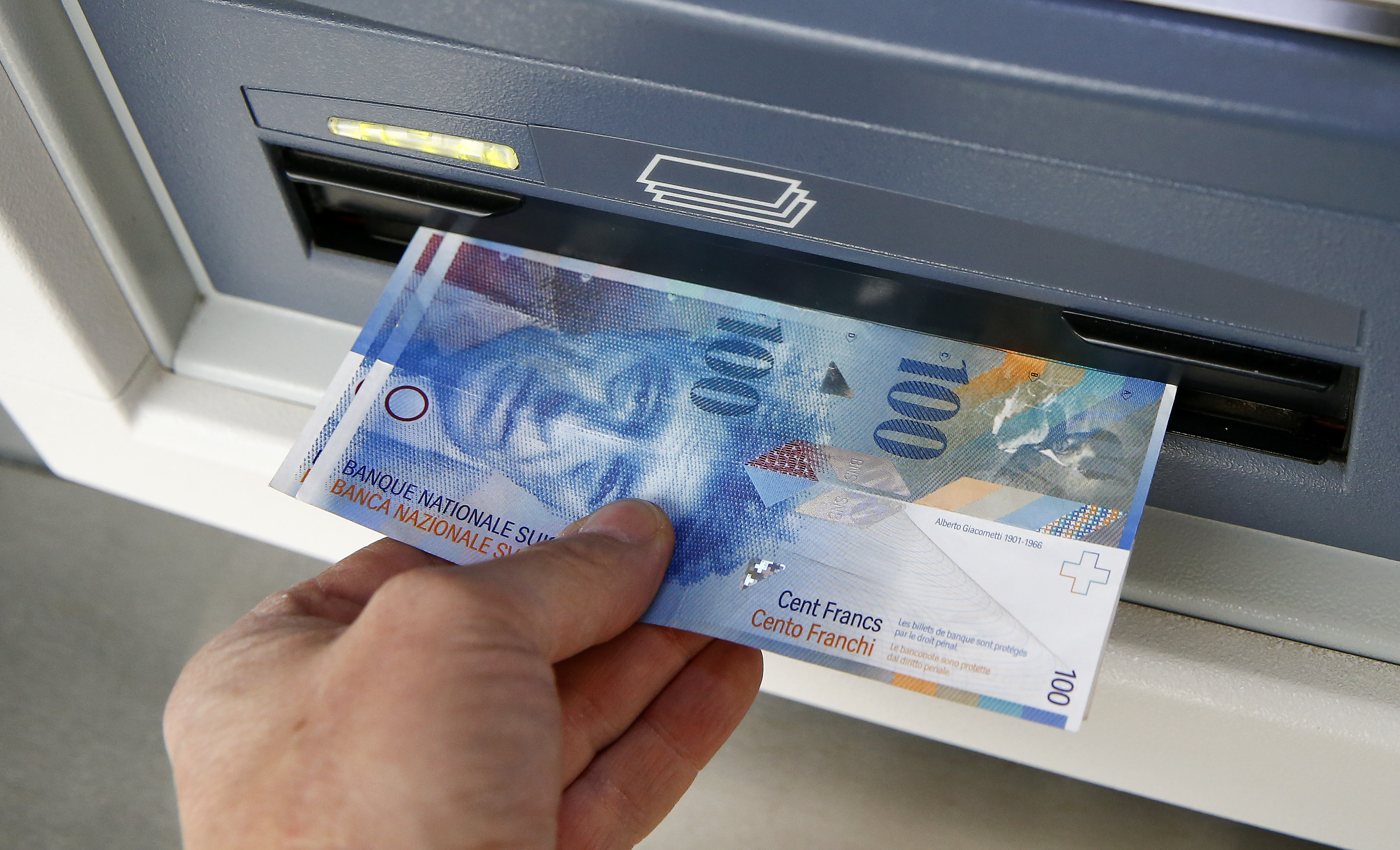 Swiss 100 franc bank notes are withdrawn from an ATM in the northern Swiss town of Kreuzlingen in this picture illustration
