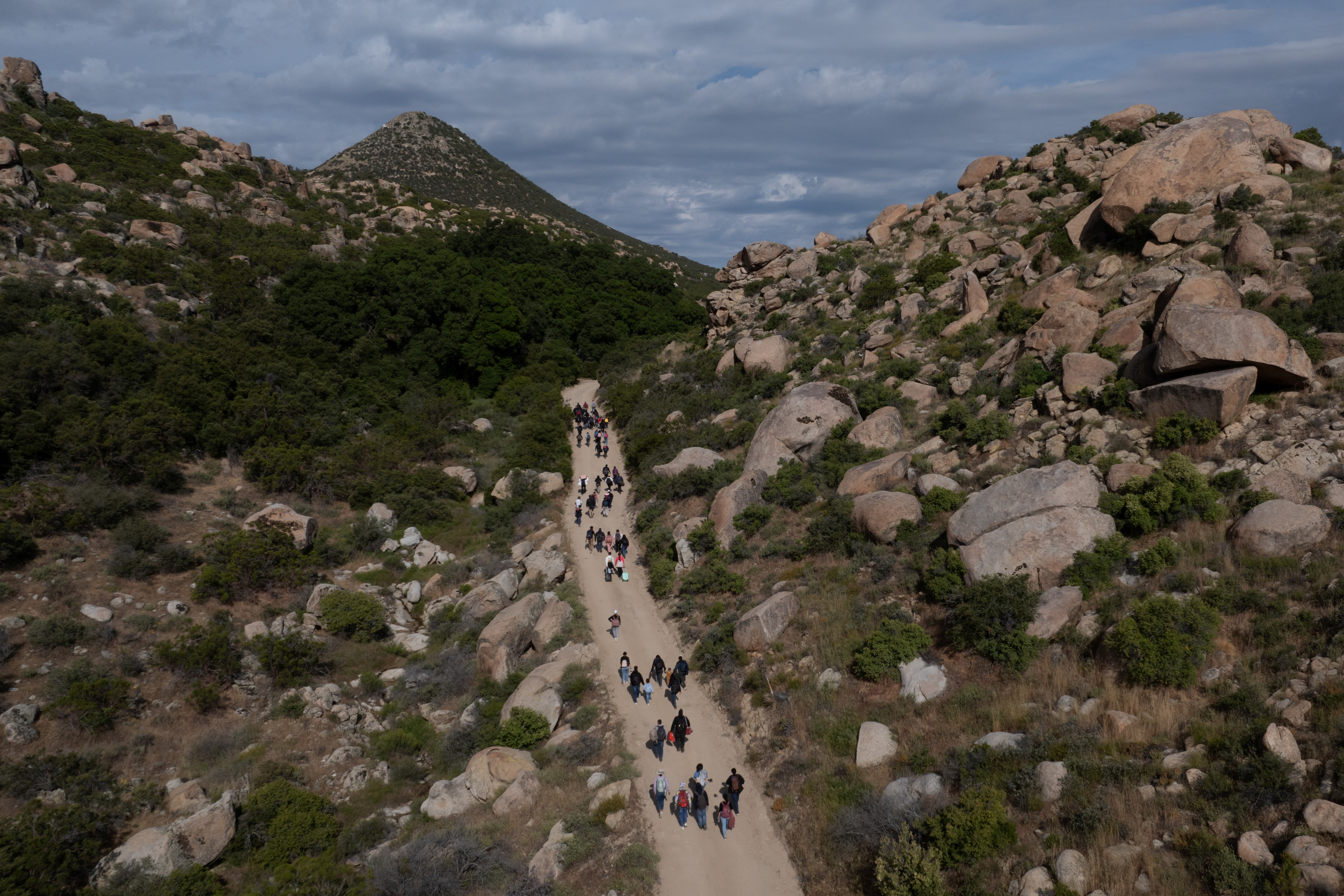 Migrants from China and Turkey climb hill in Jacumba Hot Springs, California