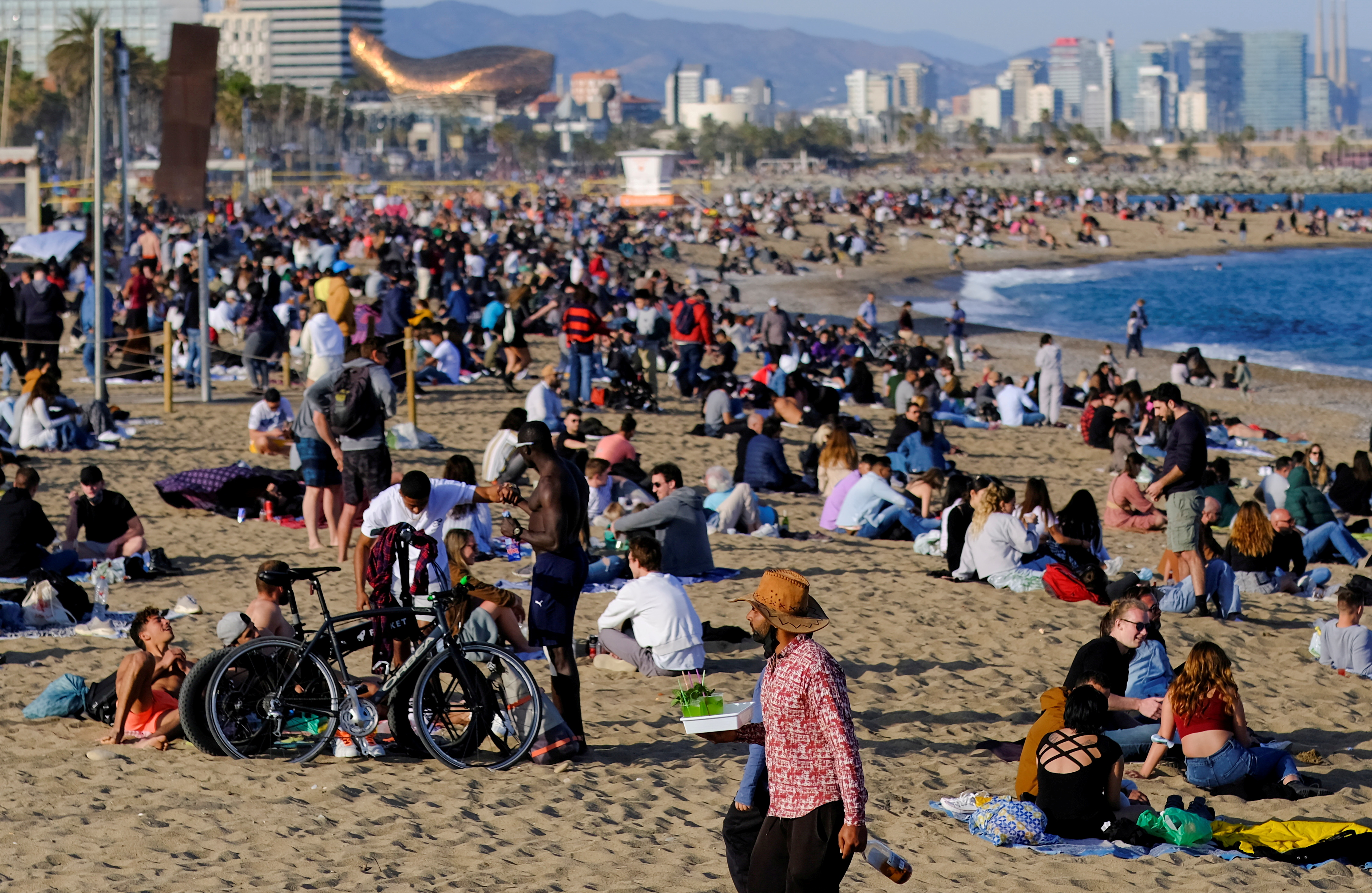 People spend time at Barceloneta beach, in Barcelona