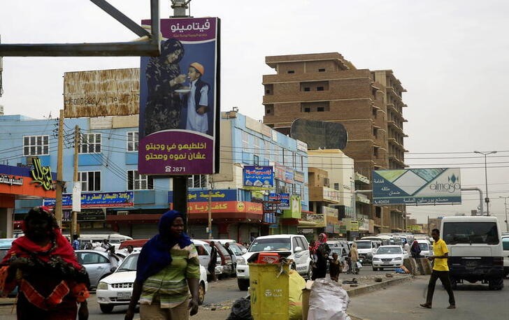 A general view shows Sudanese people and traffic along a street in Khartoum