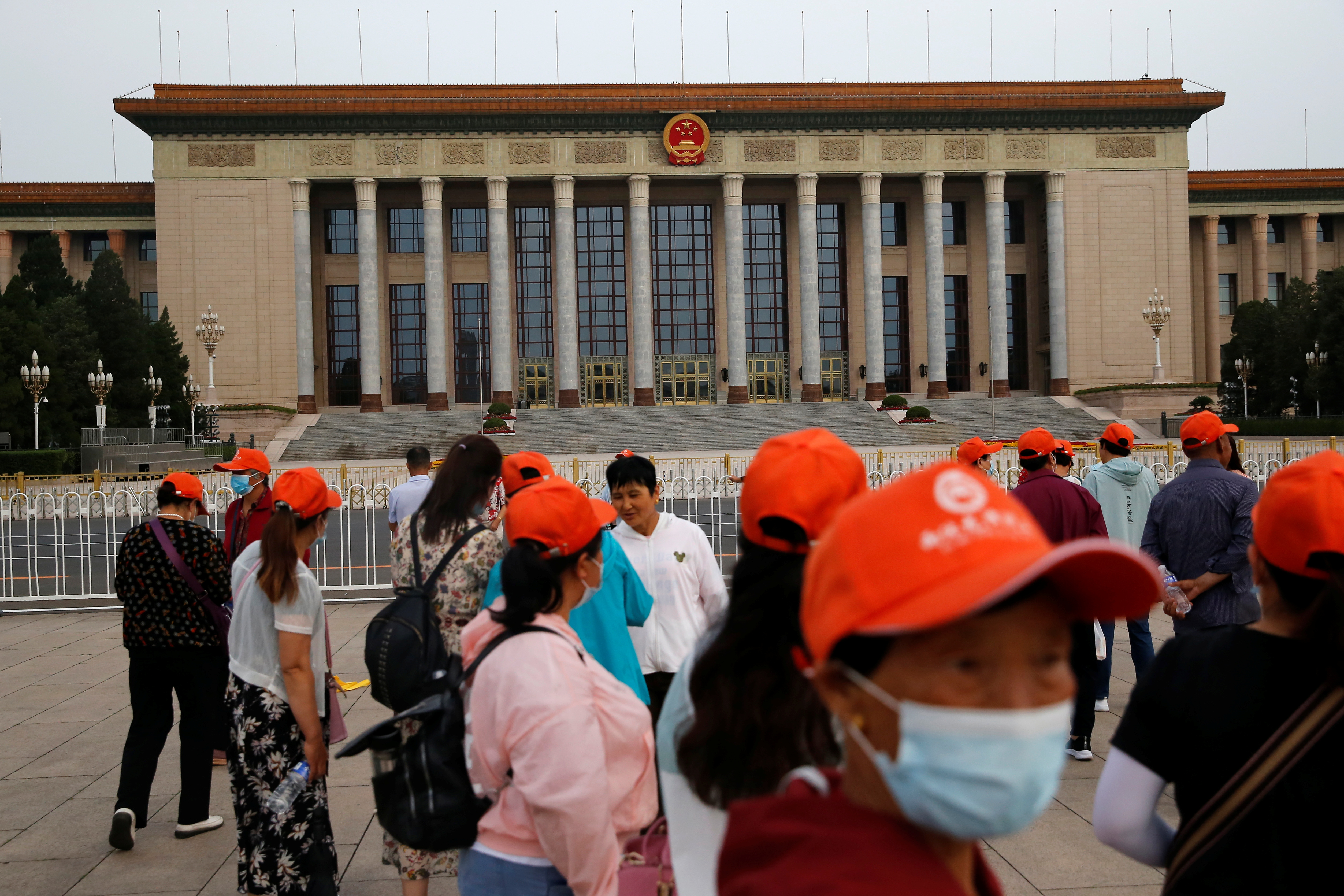 Tourists are seen near the Great Hall of the People, at Tiananmen Square, in Beijing