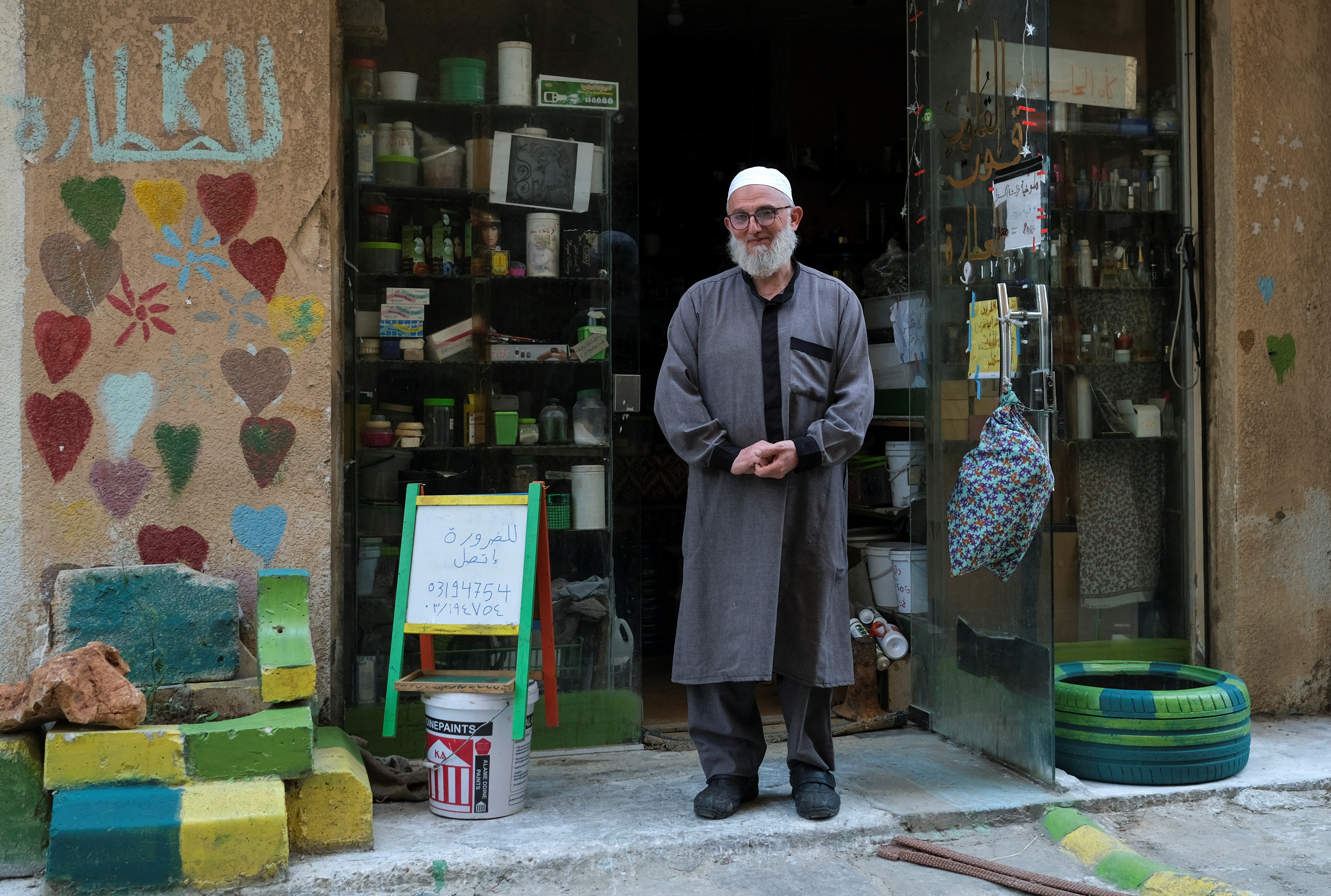 Mohammad Abadeen poses outside his shop in Tripoli