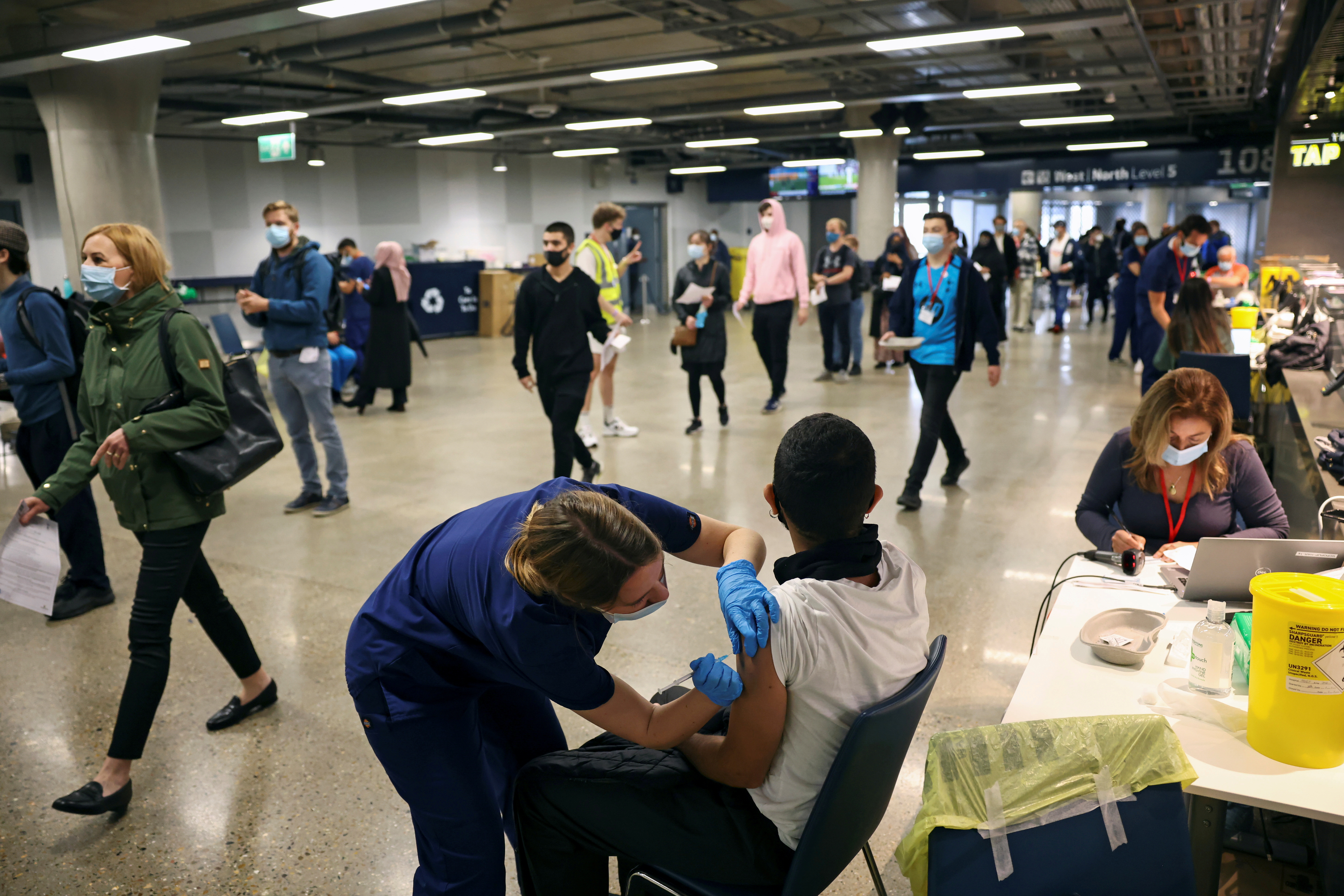 A person receives a dose of the Pfizer BioNTech COVID-19 vaccine at a mass vaccination centre for those aged 18 and over at the Tottenham Hotspur Stadium, amid the coronavirus disease (COVID-19) pandemic, in London, Britain, June 20, 2021. REUTERS/Henry Nicholls/File Photo