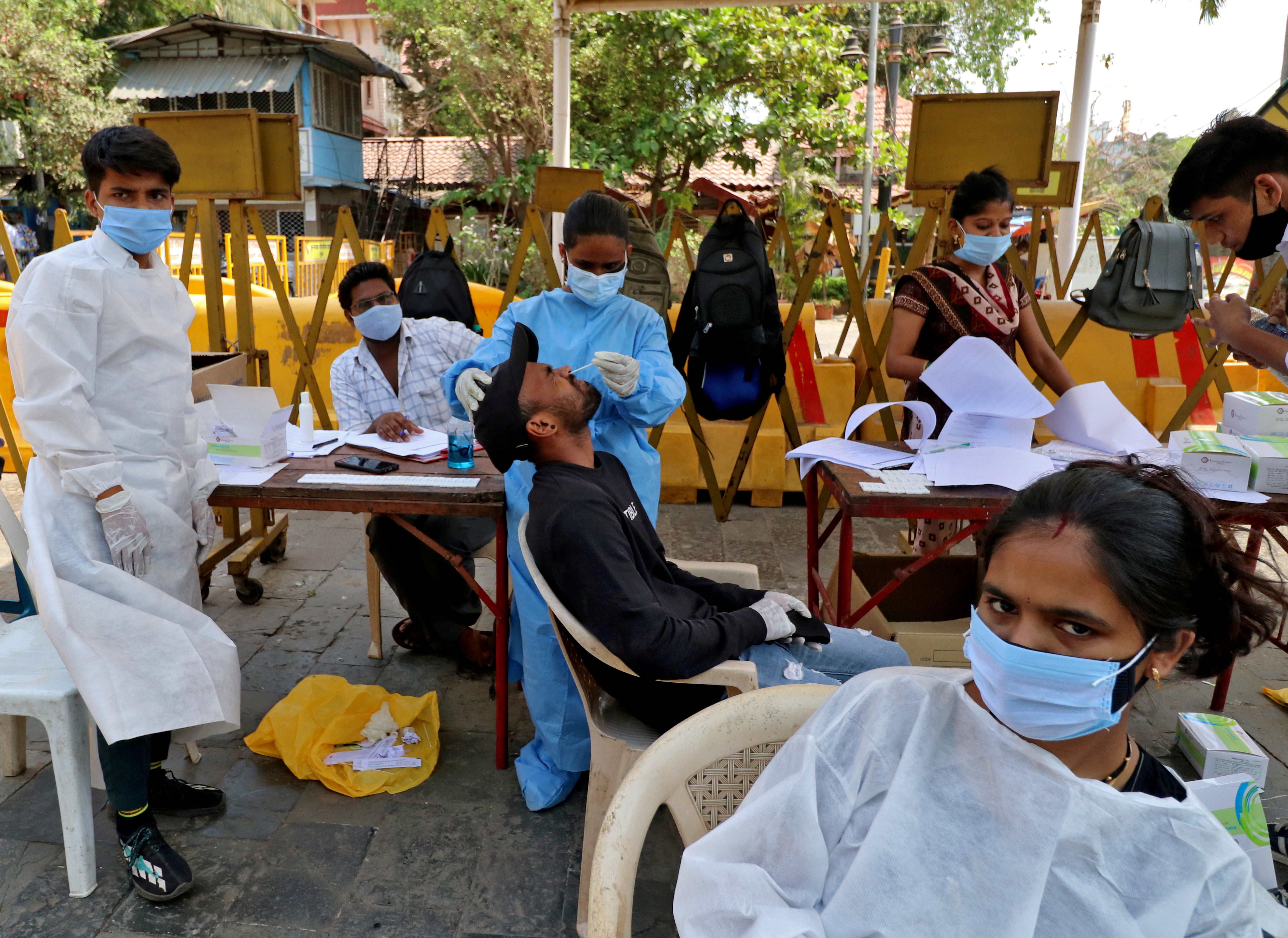A healthcare worker collects a swab sample from a man during a rapid antigen testing campaign for the coronavirus disease (COVID-19), in Mumbai