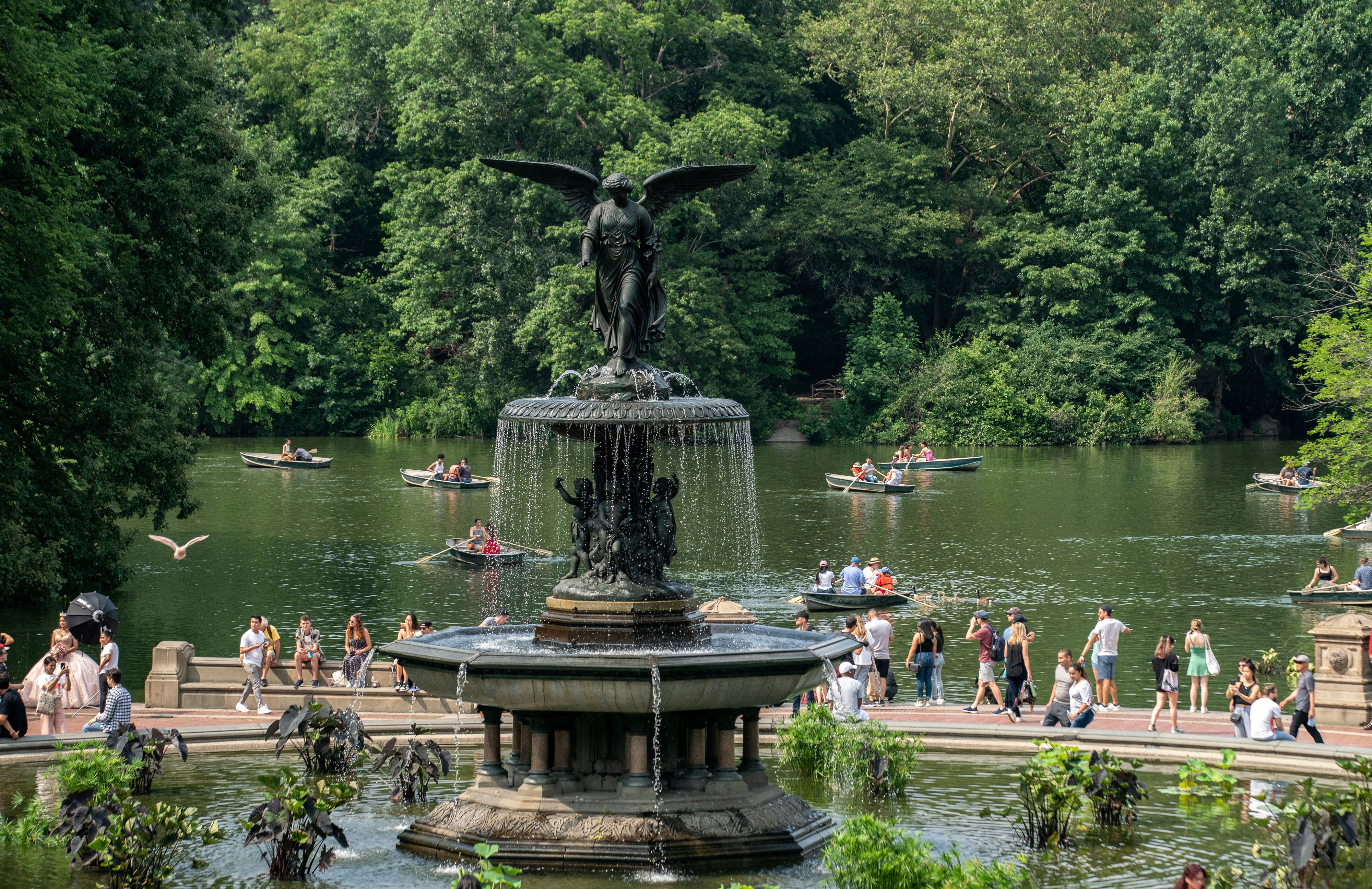People row boats past the Bethesda Fountain in Central Park in New York City