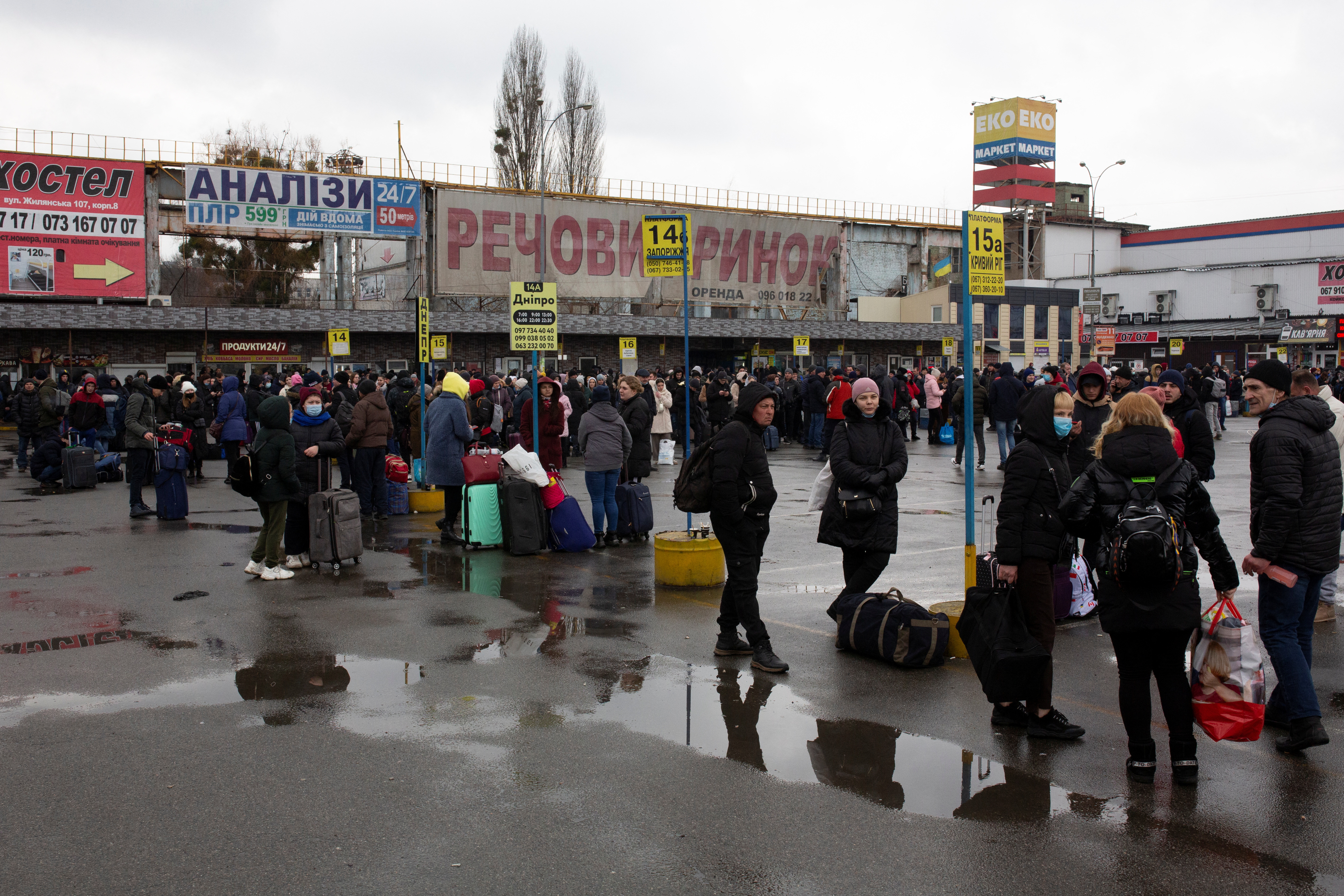 People gather at a bus station as they try to leave Kyiv