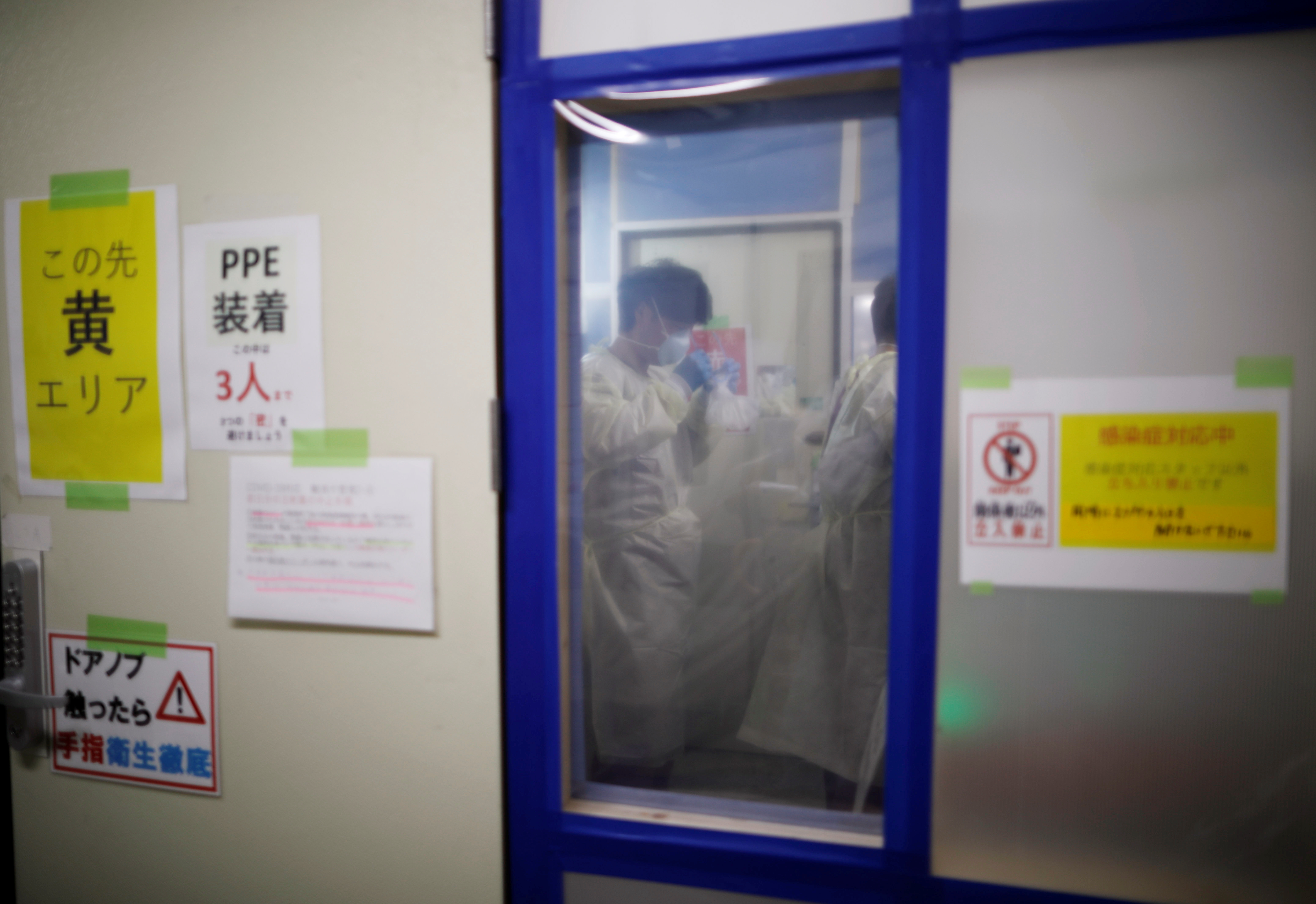 Medical workers prepare to put on PPE as they work in the ICU for the coronavirus disease (COVID-19) patients at St. Marianna Medical University Hospital in Kawasaki, Japan