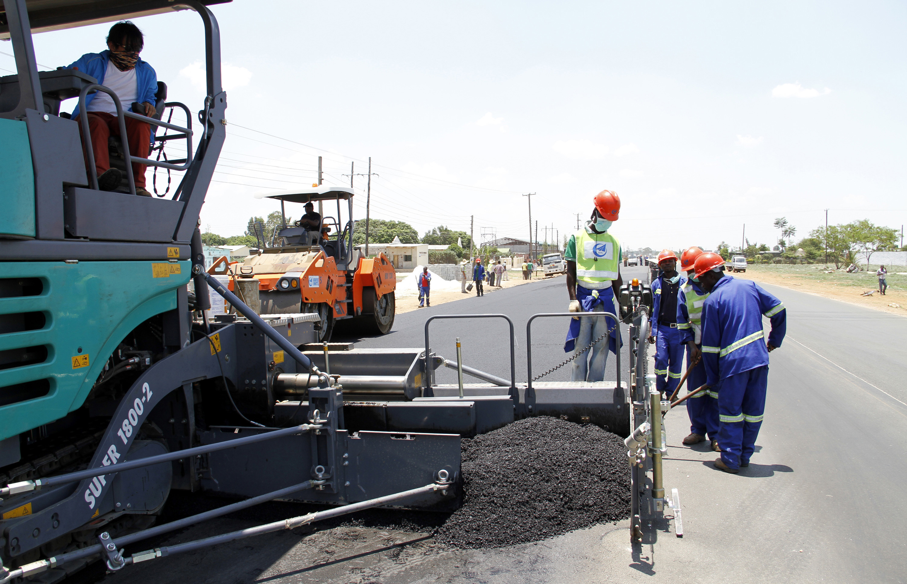 Labourers carry out surfacing work on a road near the Zambian capital Lusaka