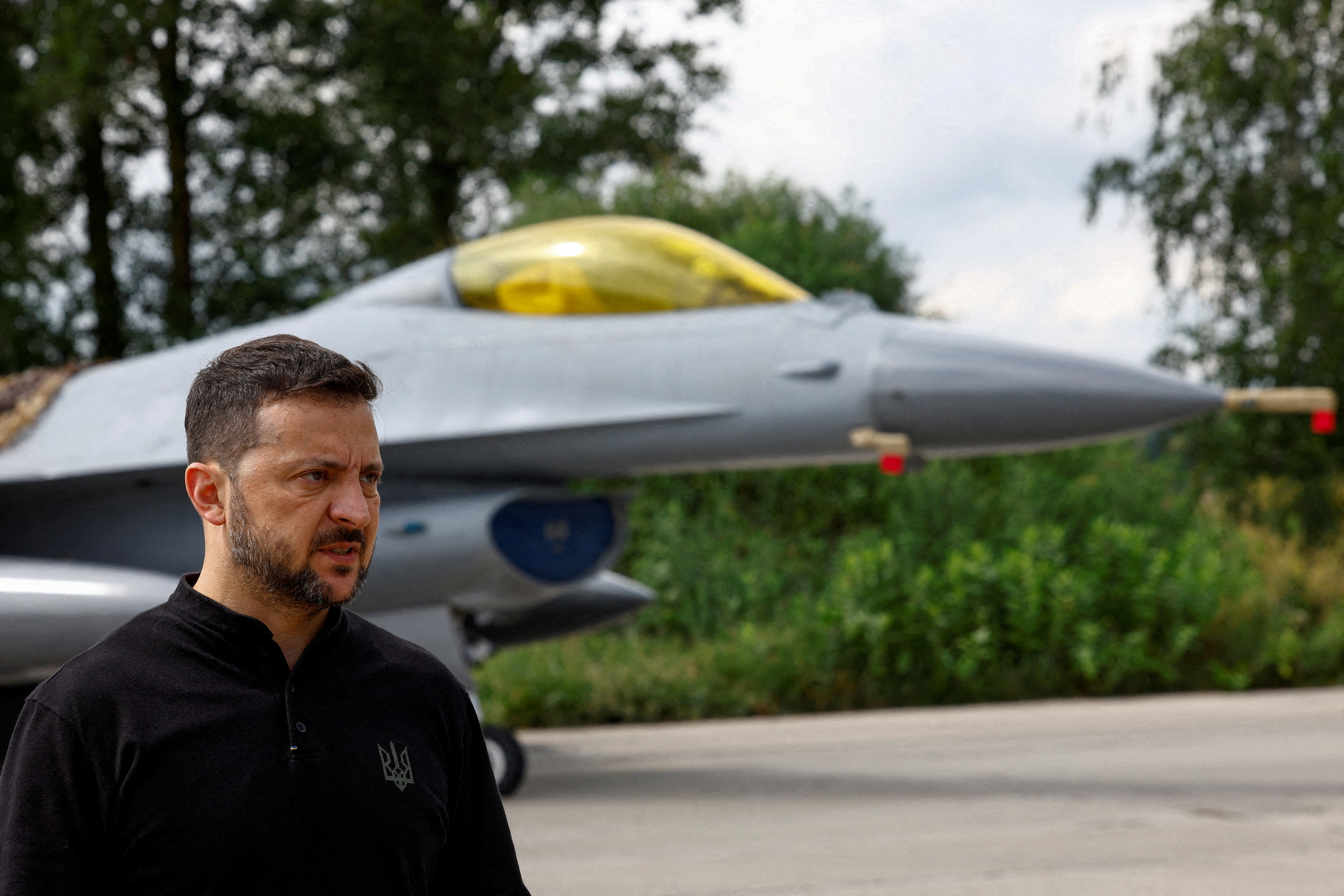 El presidente de Ucrania, Zelenskiy, habla con los medios de comunicación frente a un avión de combate F-16 después de conmemorar el Día de las Fuerzas Aéreas de Ucrania en un lugar no revelado en Ucrania.