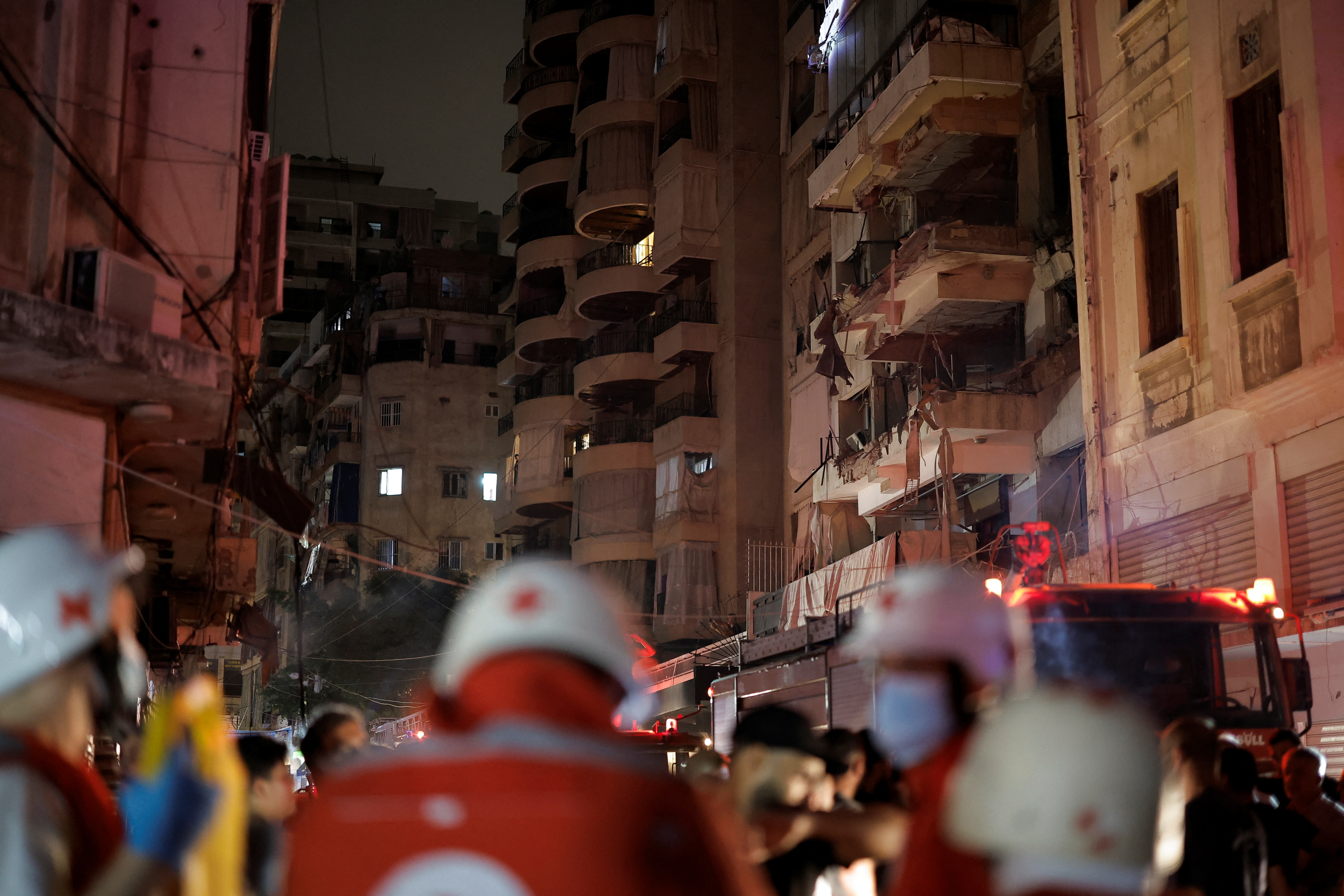 Members of the Red Cross stand near a damaged building at the site of an Israeli air strike, in Beirut