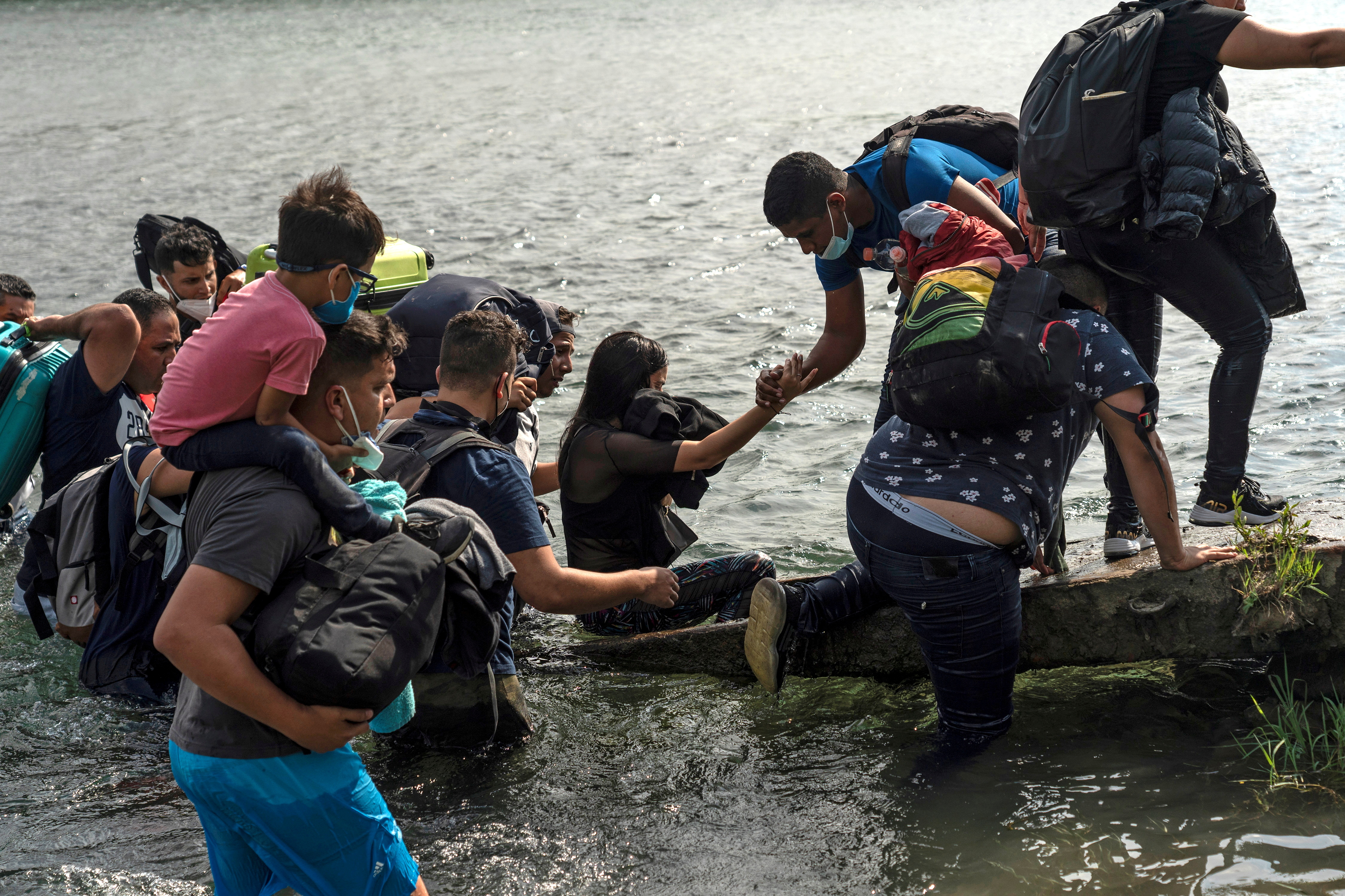 Asylum-seeking migrants cross the Rio Grande river in Del Rio