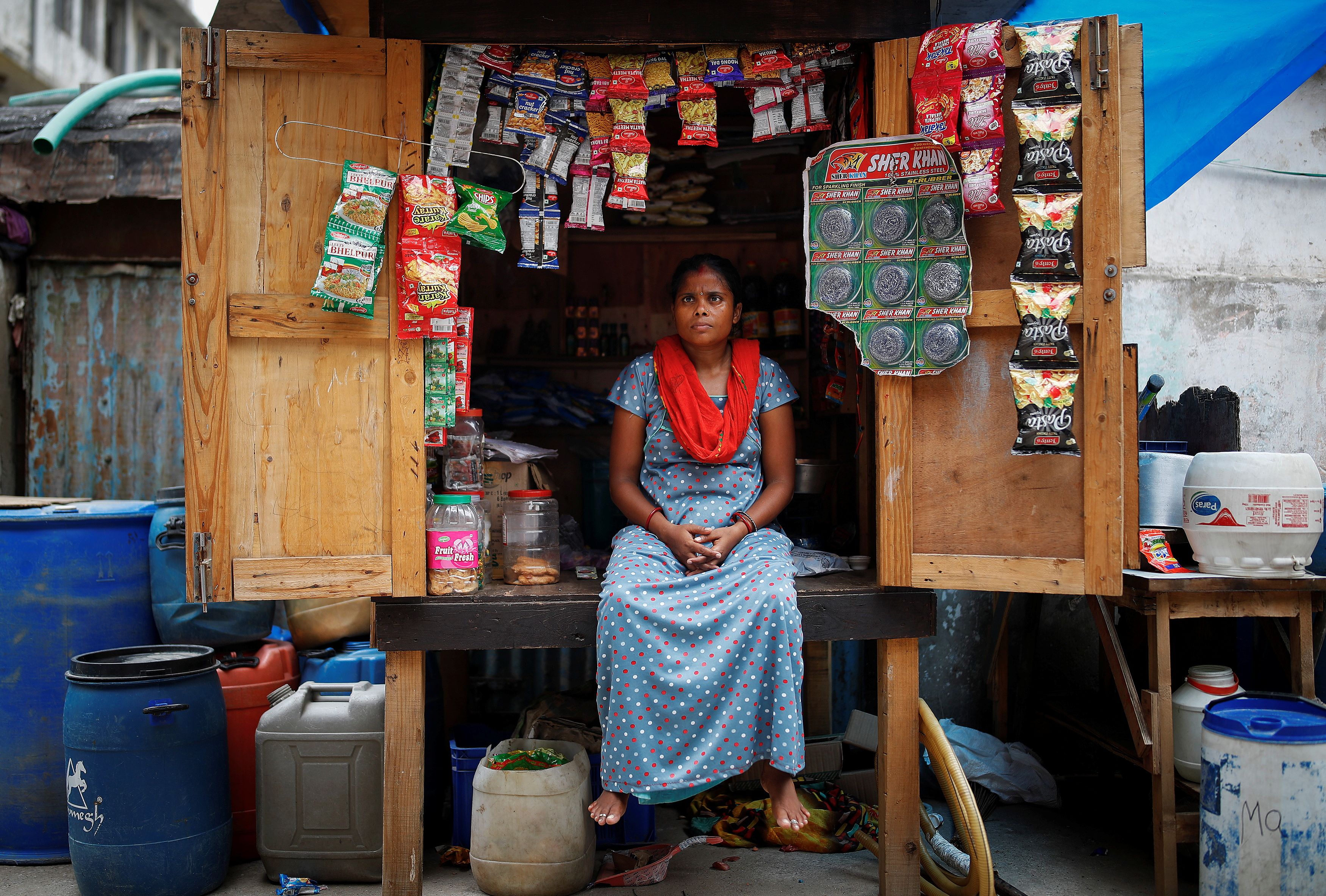 Chineya Devi who lost her job in a packaging firm, sits inside her roadside stall, in New Delhi